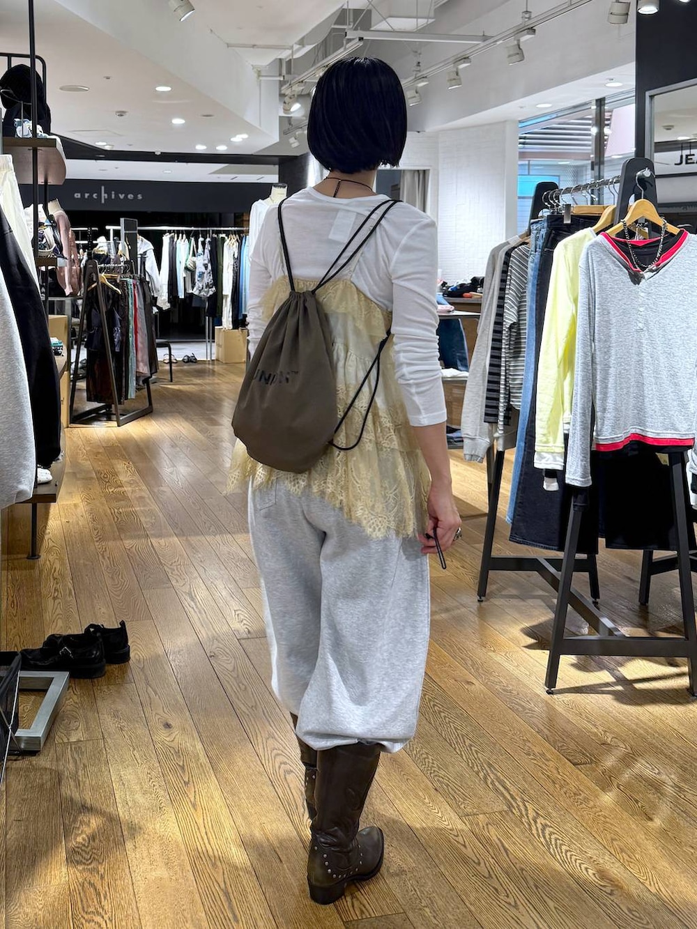 ホワイト系のTシャツ/カットソー、ブラック系のブーツ、グレー系のスウェットパンツを着用したレディースの春コーディネートの3枚目の写真