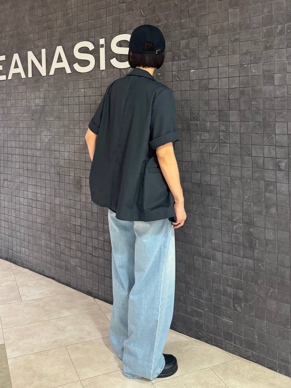 ブラック系のローファー、ブルー系のデニムパンツ、レッド系のタンクトップを着用したレディースの春コーディネートの4枚目の写真