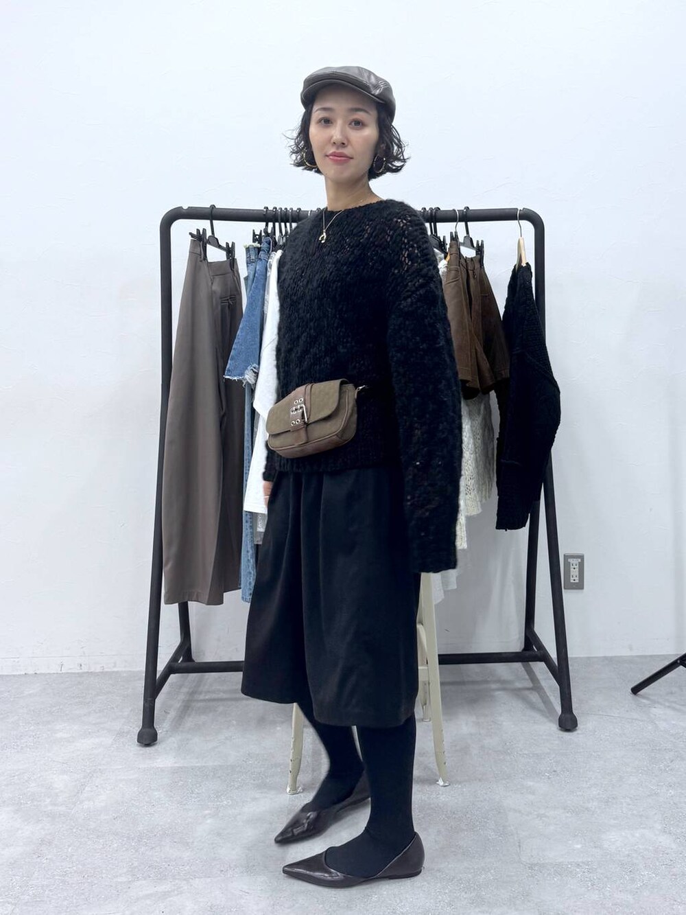 ブラック系のその他パンツ、ブラック系のニット/セーター、ブラウン系のハンチング/ベレー帽を着用したレディースの秋コーディネートの3枚目の写真