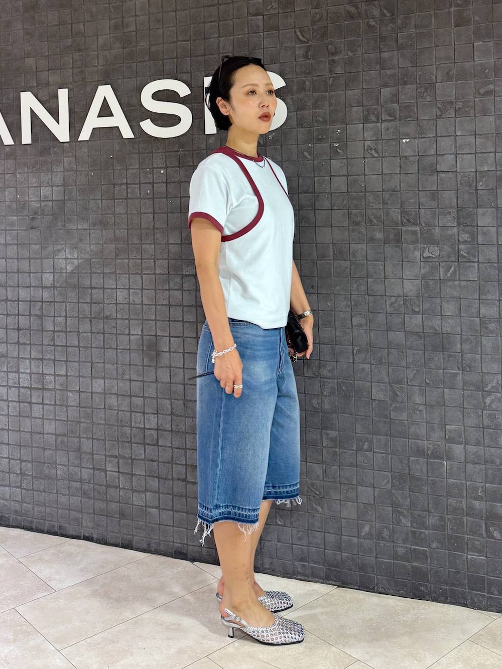 ブルー系のデニムパンツ、シルバー系のパンプスを着用したレディースの夏コーディネートの3枚目の写真
