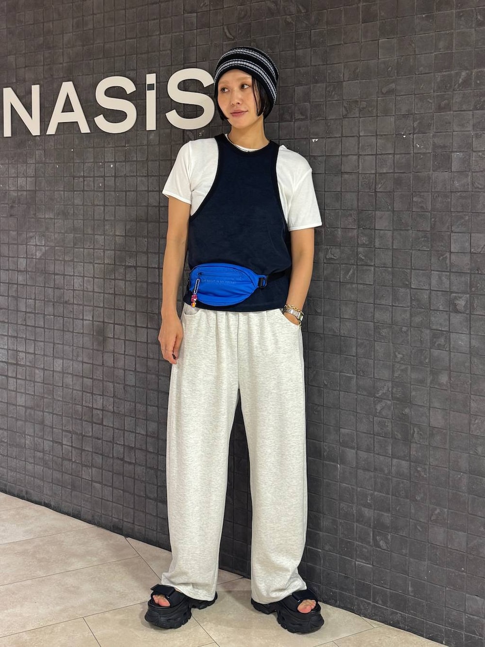 ブラック系のサンダル、ホワイト系のTシャツ/カットソー、ベージュ系のスウェットパンツを着用したレディースの夏コーディネートの5枚目の写真