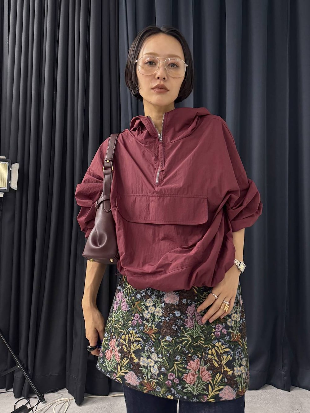 レッド系のショルダーバッグ、ブルー系のデニムパンツ、ブラック系のスカートを着用したレディースの夏コーディネートの2枚目の写真