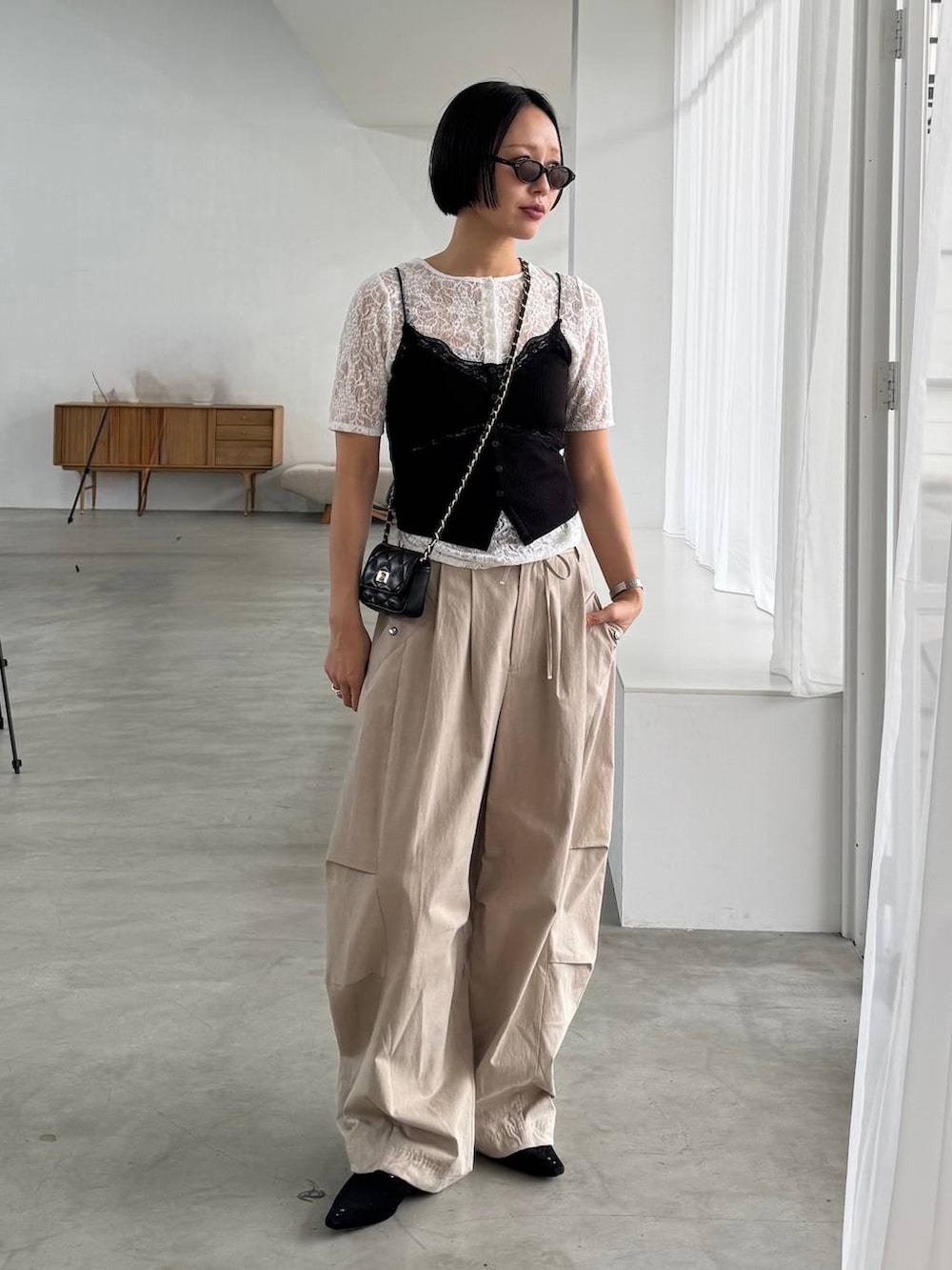 ブラック系のパンプス、ベージュ系のその他パンツ、ホワイト系のTシャツ/カットソーを着用したレディースの春コーディネートの4枚目の写真
