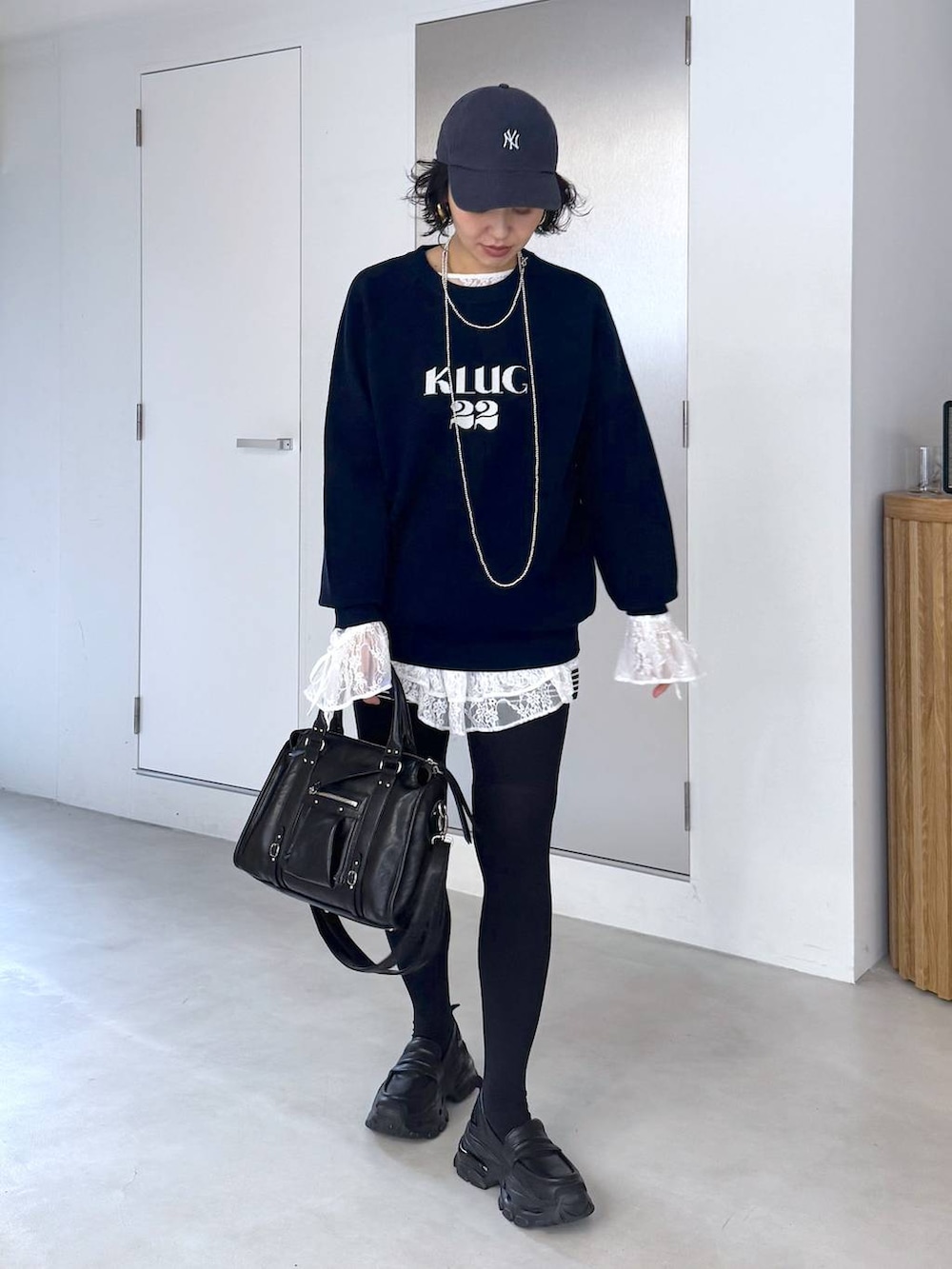 ブラック系のボストンバッグ、ホワイト系のシャツ/ブラウスを着用したレディースの秋コーディネートの2枚目の写真