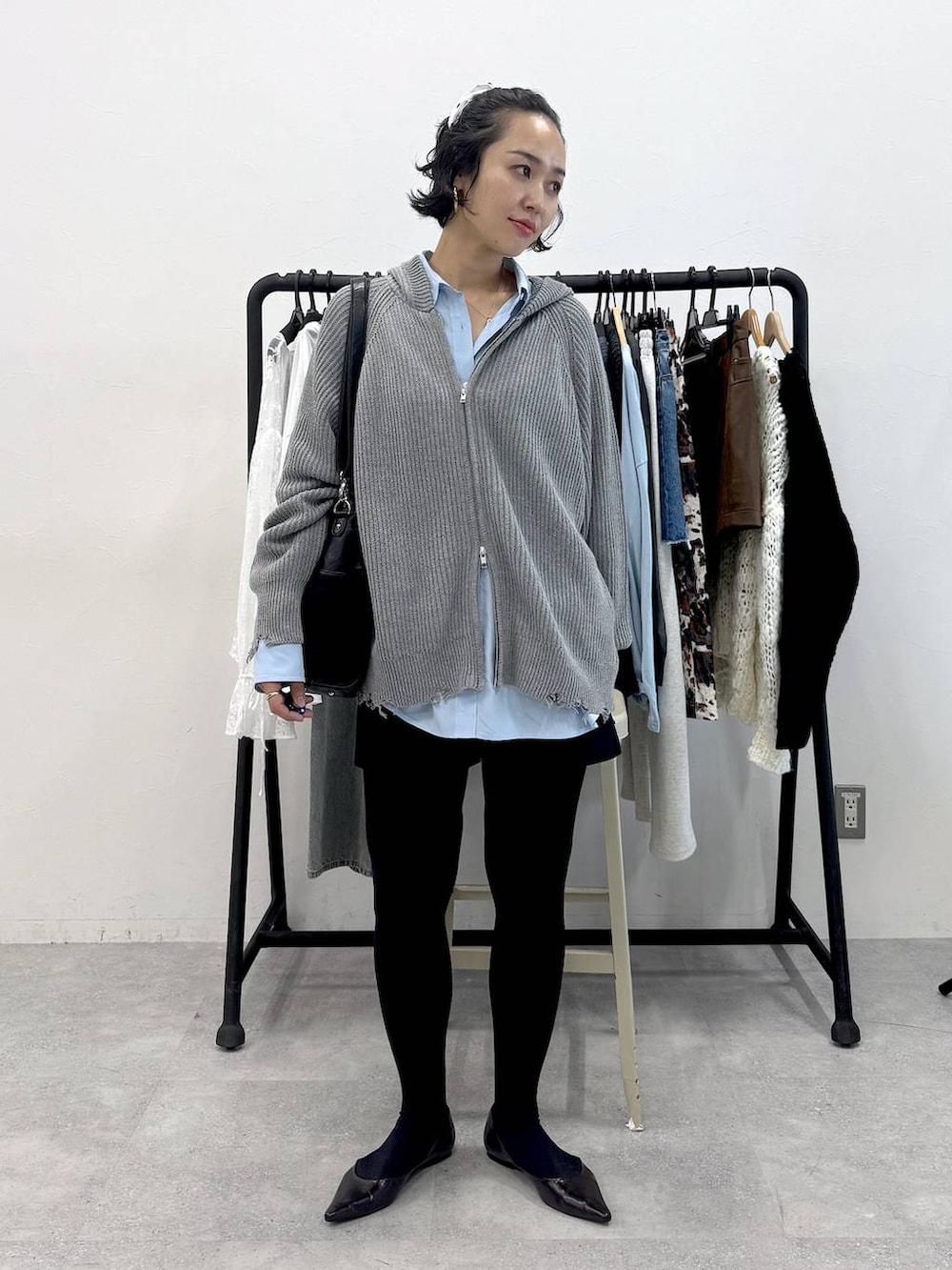 ブラック系のトートバッグ、ブルー系のシャツ/ブラウス、ブラック系のスカートを着用したレディースの秋コーディネートの5枚目の写真