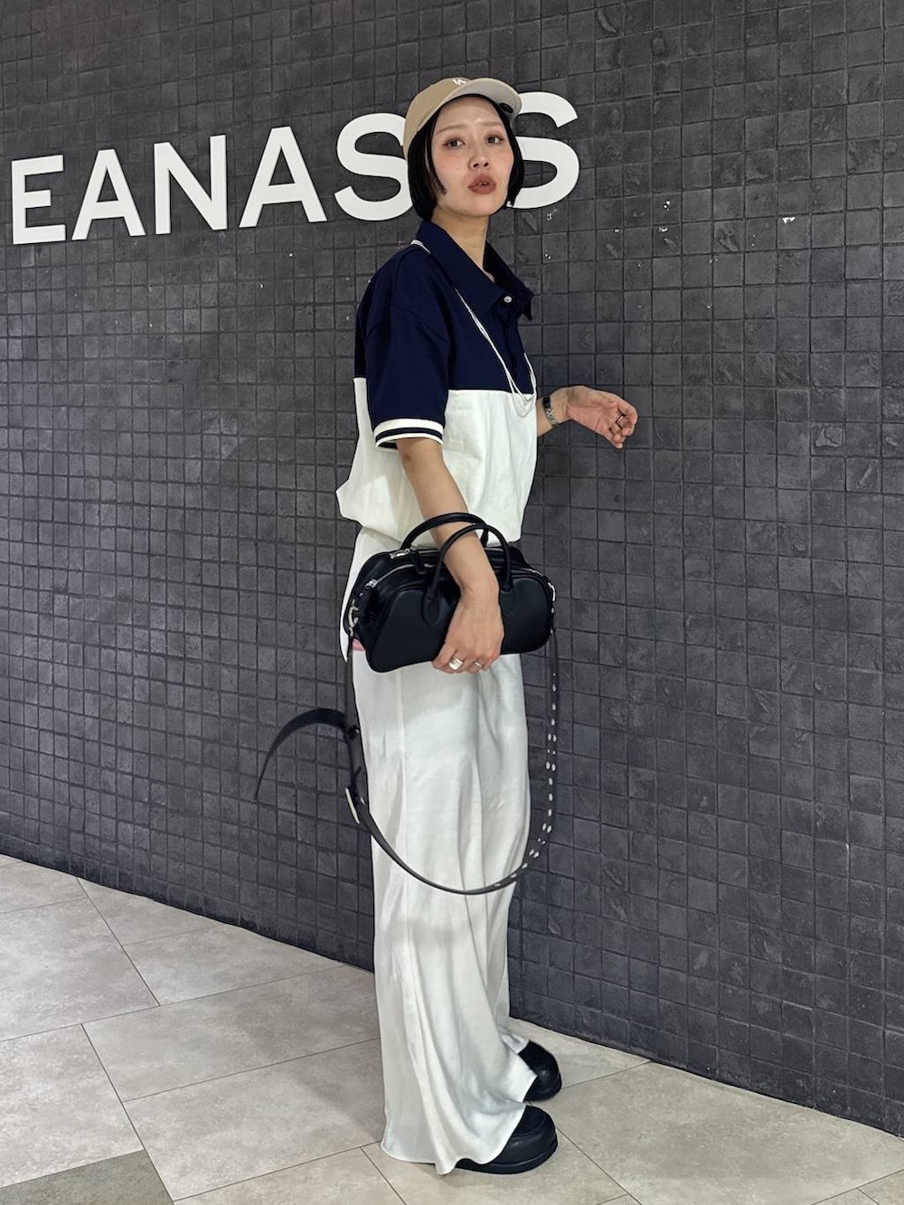 ブラック系のボストンバッグ、ブラック系のスカート、ブラック系のローファーを着用したレディースの春コーディネートの6枚目の写真