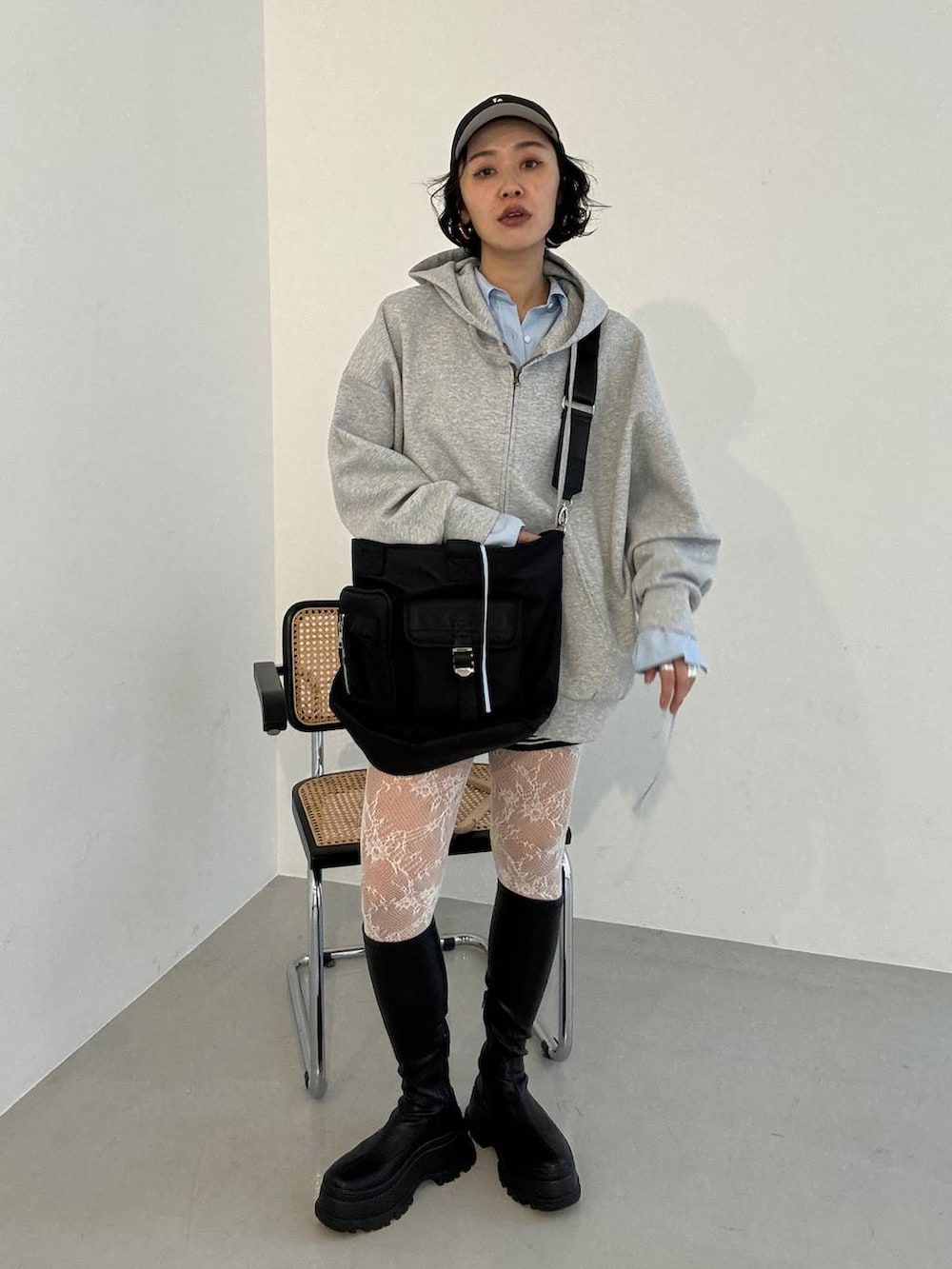 ブラック系のブーツ、ブラック系のトートバッグ、グレー系のパーカーを着用したレディースの冬コーディネートの4枚目の写真