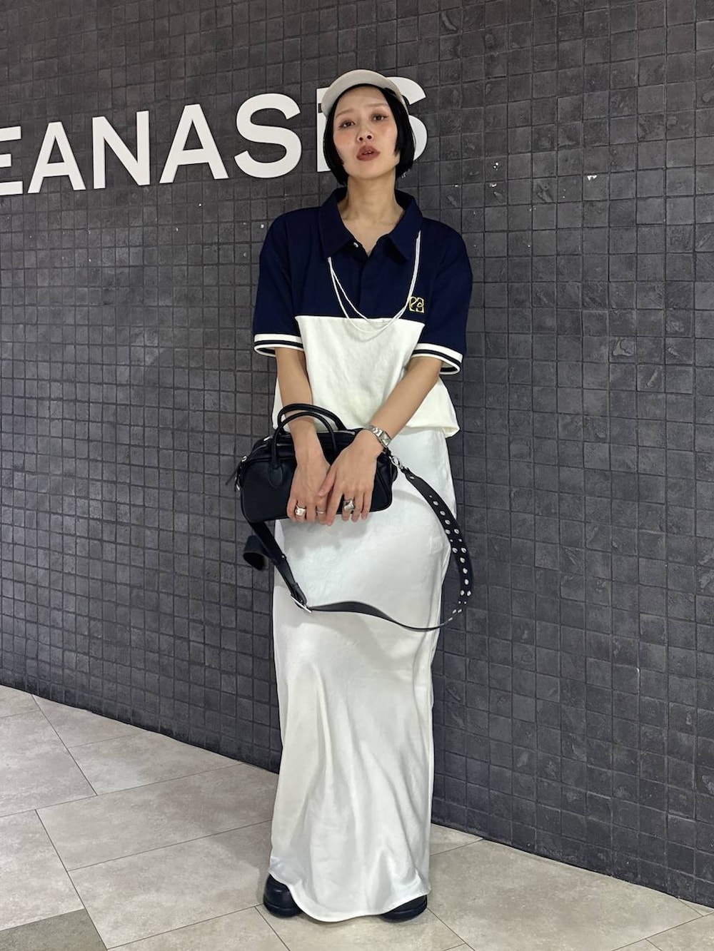 ブラック系のボストンバッグ、ブラック系のスカート、ブラック系のローファーを着用したレディースの春コーディネートの2枚目の写真