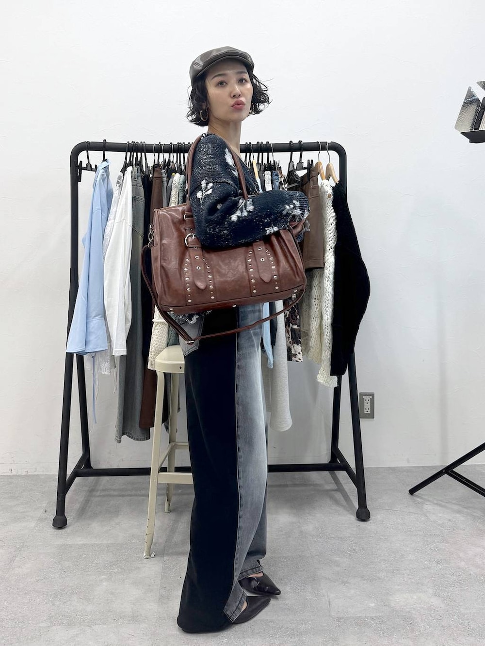 ブラック系のデニムパンツ、グリーン系のトートバッグ、ブラック系のカーディガン/ボレロを着用したレディースの秋コーディネートの3枚目の写真