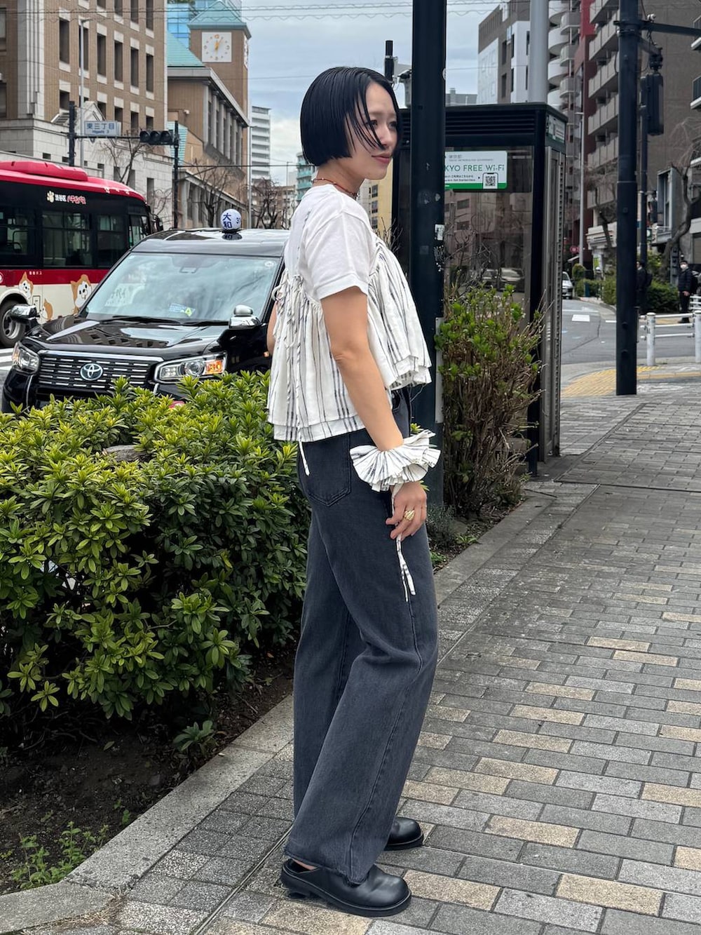 ブラック系のサンダル、ブラック系のデニムパンツを着用したレディースの春コーディネートの4枚目の写真