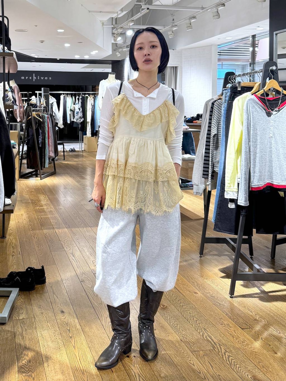 ホワイト系のTシャツ/カットソー、ブラック系のブーツ、グレー系のスウェットパンツを着用したレディースの春コーディネートの5枚目の写真