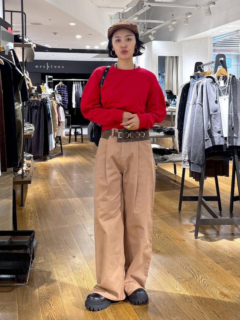 ベージュ系のデニムパンツ、ブラック系のショルダーバッグ、ブラック系のブーツを着用したレディースの秋コーディネートの9枚目の写真