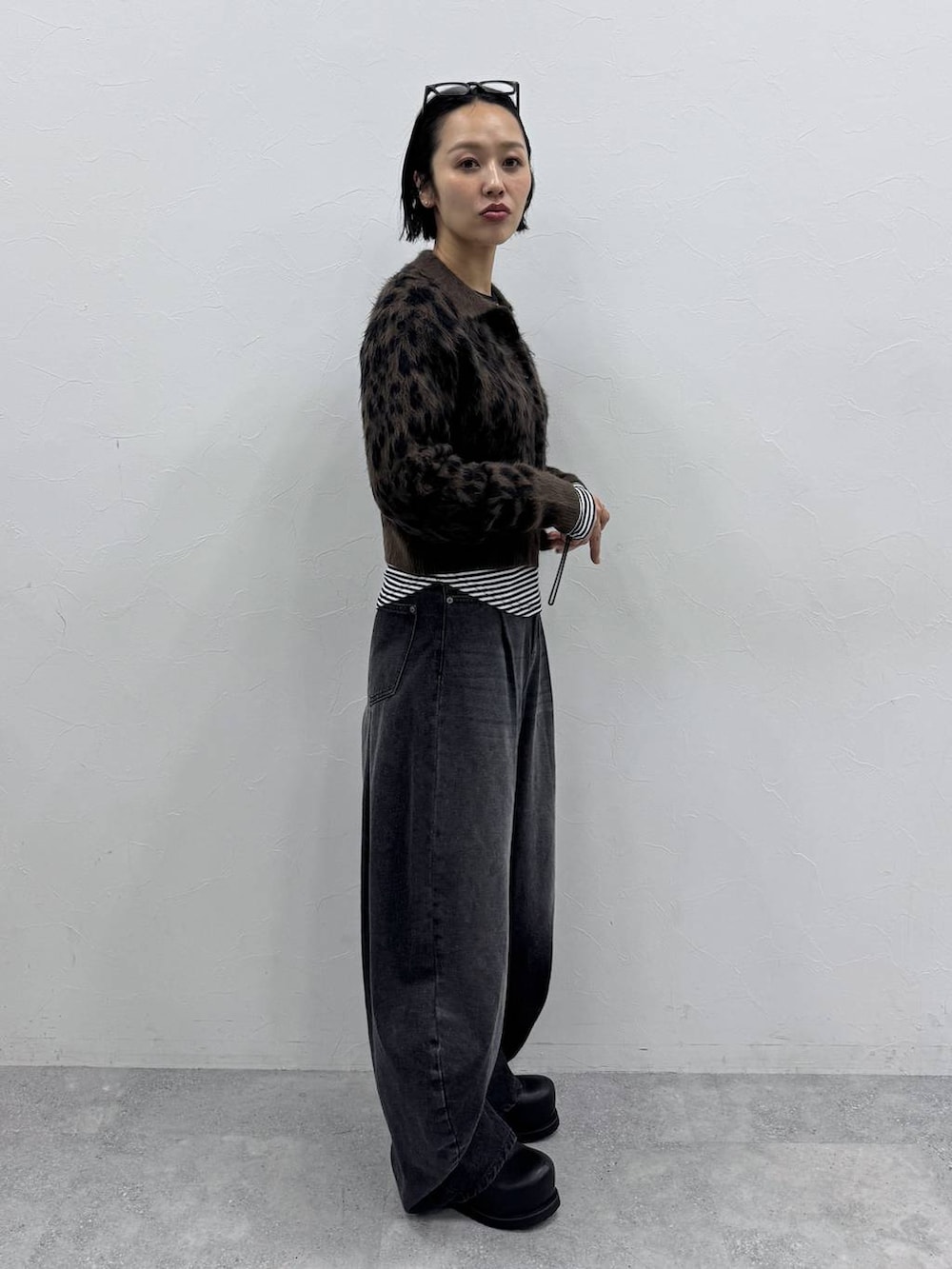 ブラック系のデニムパンツ、ブラウン系のカーディガン/ボレロ、ブラック系のTシャツ/カットソーを着用したレディースの秋コーディネートの2枚目の写真