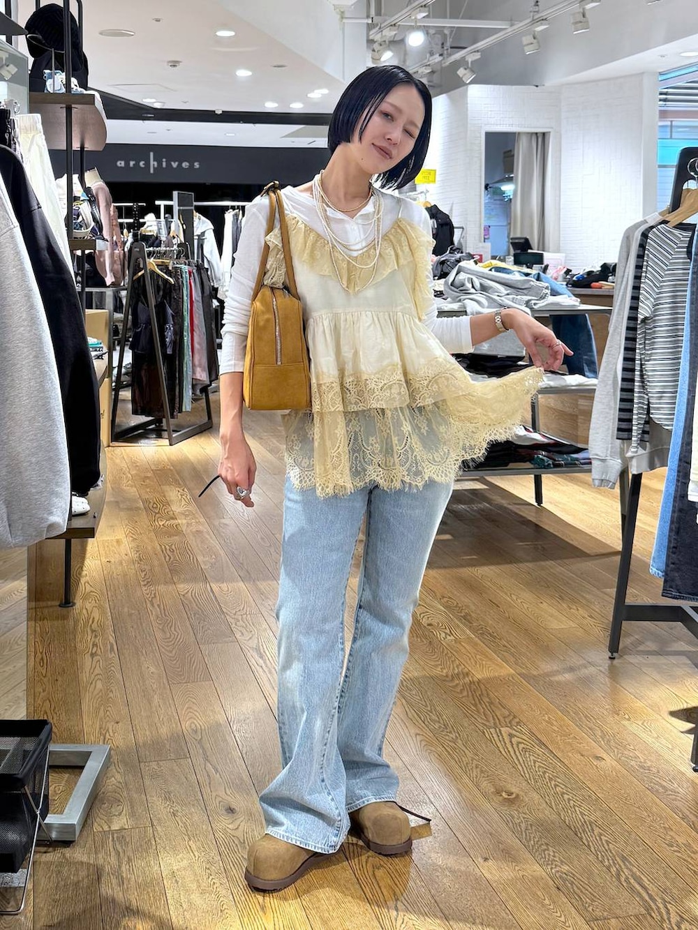 ホワイト系のTシャツ/カットソー、ブラウン系のボストンバッグ、ベージュ系のモカシン/デッキシューズを着用したレディースの春コーディネートの7枚目の写真