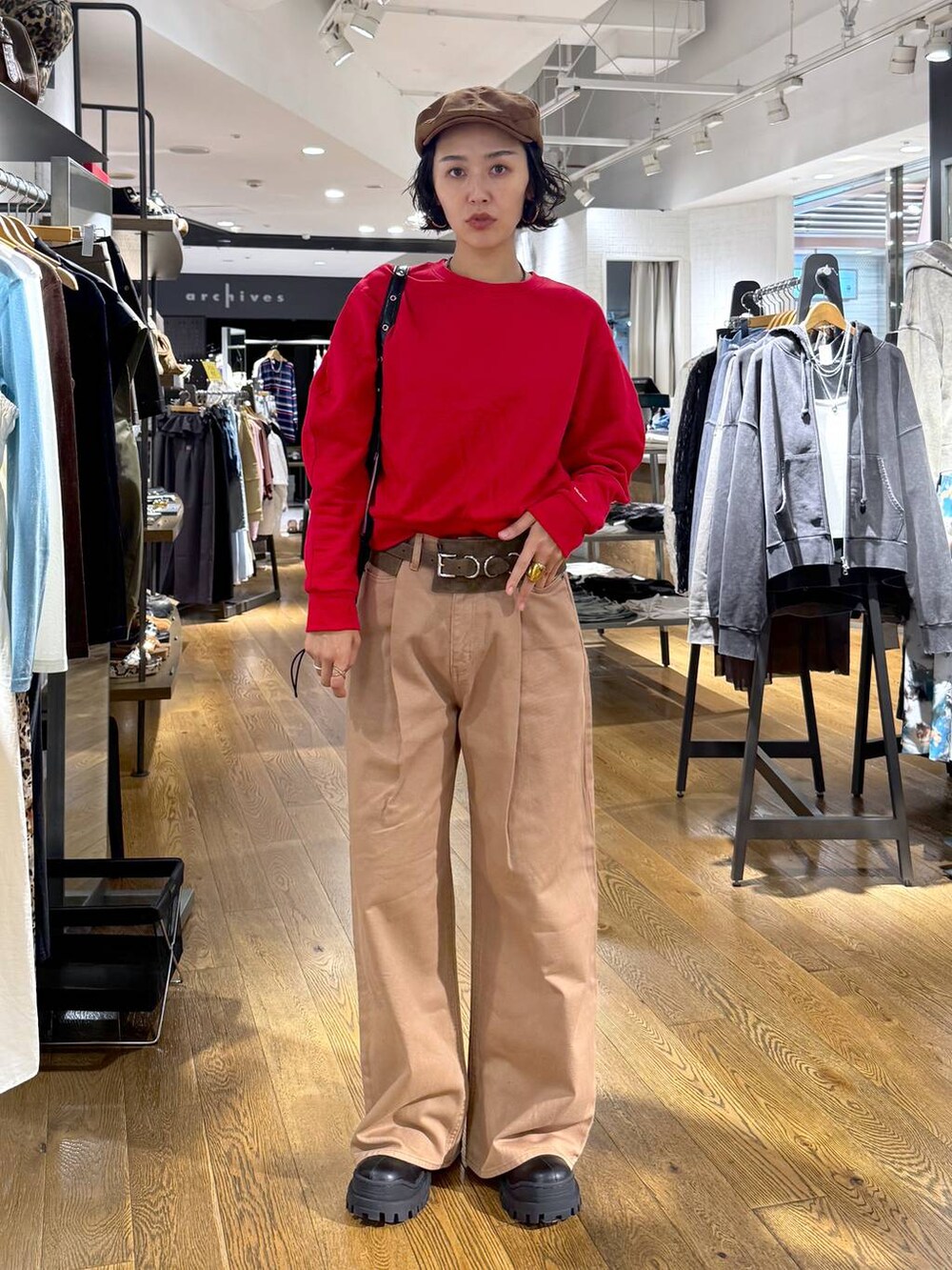 ベージュ系のデニムパンツ、ブラック系のショルダーバッグ、ブラック系のブーツを着用したレディースの秋コーディネートの3枚目の写真