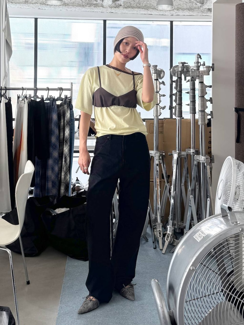 ブラック系のデニムパンツ、イエロー系のTシャツ/カットソー、ブラック系のパンプスを着用したレディースの夏コーディネートの3枚目の写真