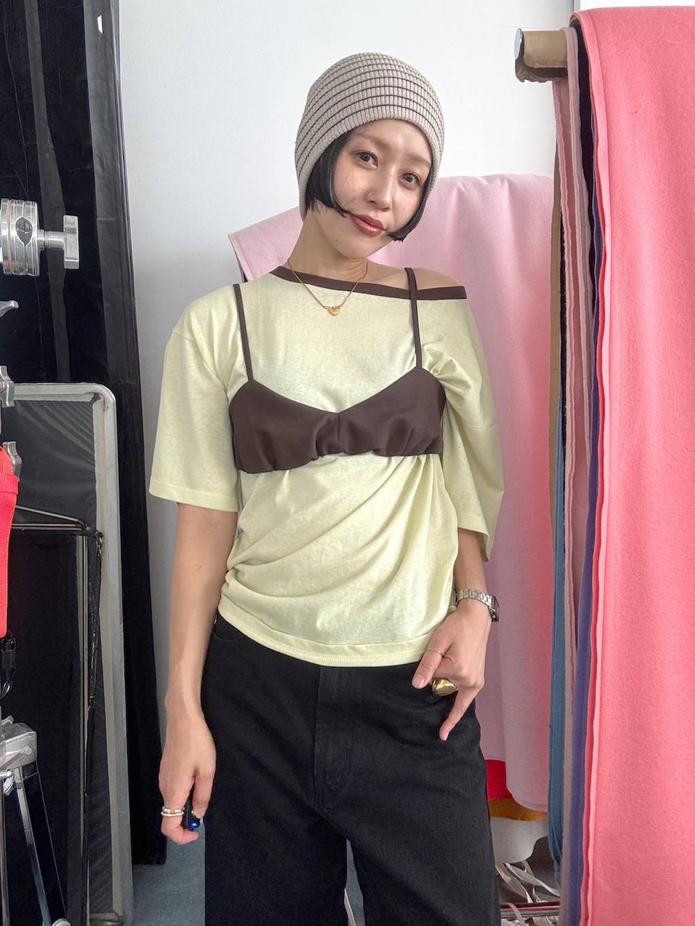 ブラック系のデニムパンツ、イエロー系のTシャツ/カットソー、ブラック系のパンプスを着用したレディースの夏コーディネートの2枚目の写真