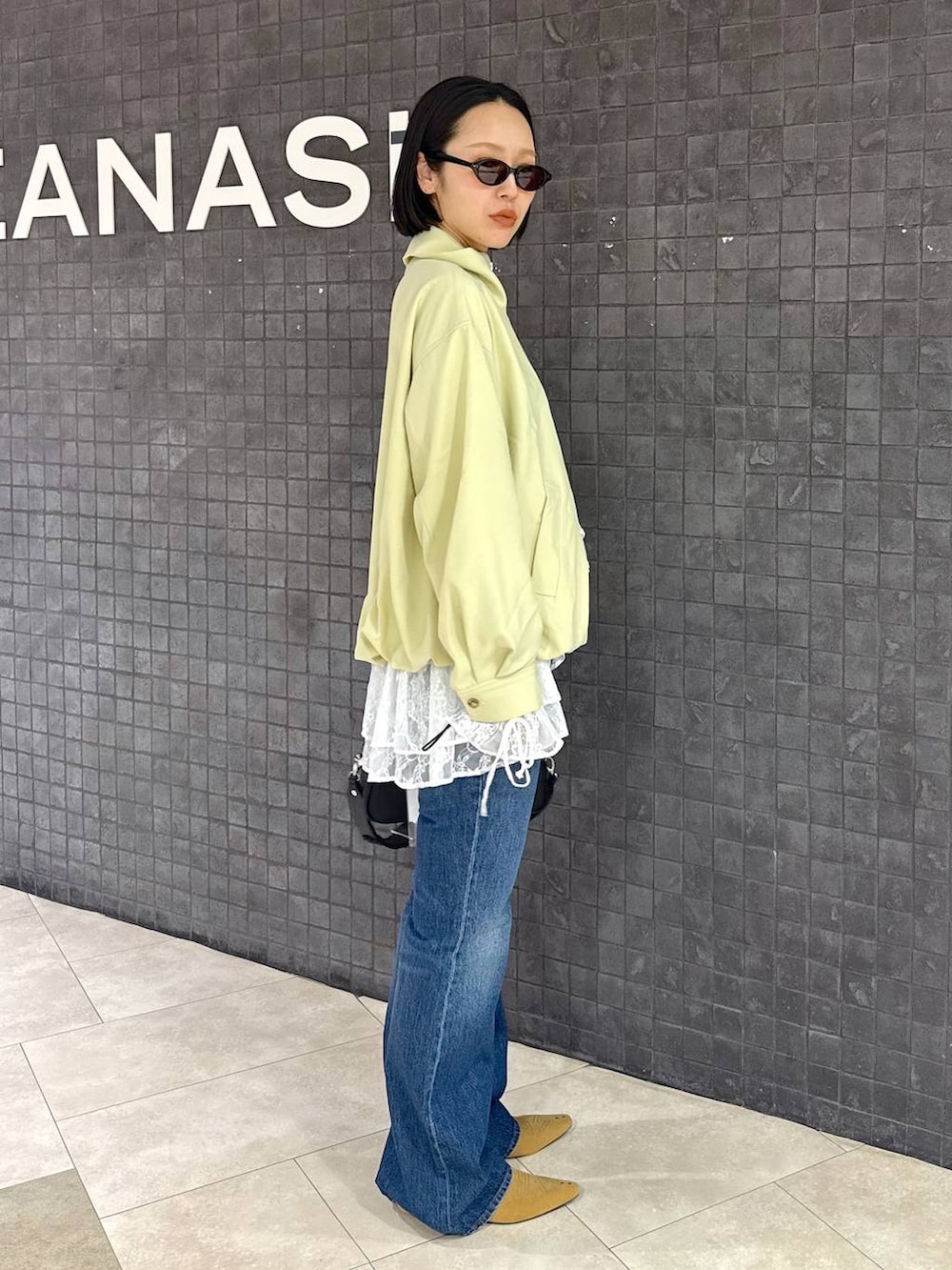 ホワイト系のシャツ/ブラウス、ブルー系のデニムパンツ、ベージュ系のパンプスを着用したレディースの春コーディネートの3枚目の写真