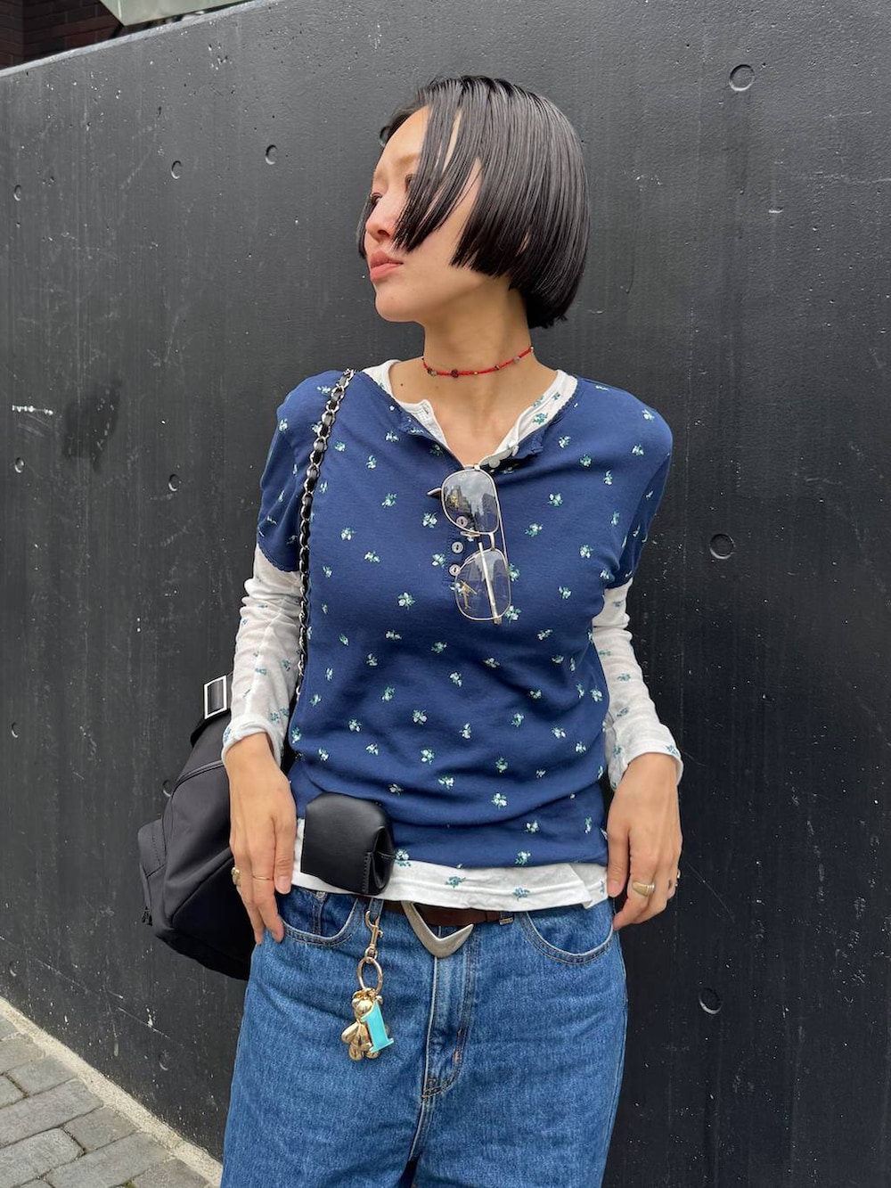 ブラック系のバックパック/リュック、ブルー系のTシャツ/カットソー、ブラウン系のベルトを着用したレディースの春コーディネートの2枚目の写真