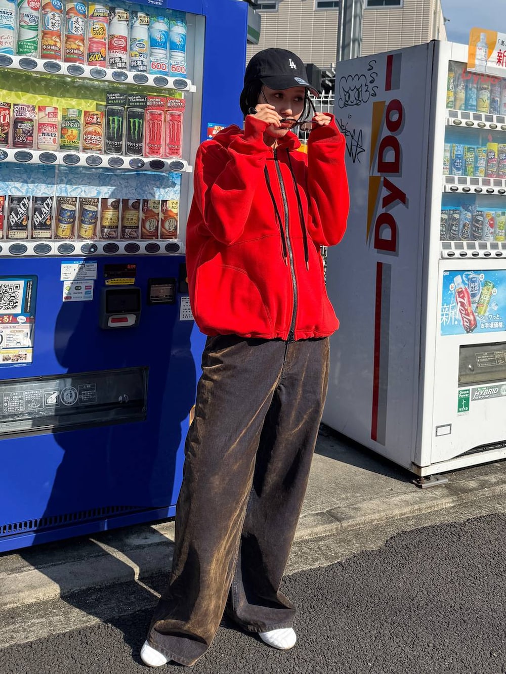 ブラウン系のデニムパンツ、レッド系のパーカーを着用したレディースの夏コーディネートの2枚目の写真