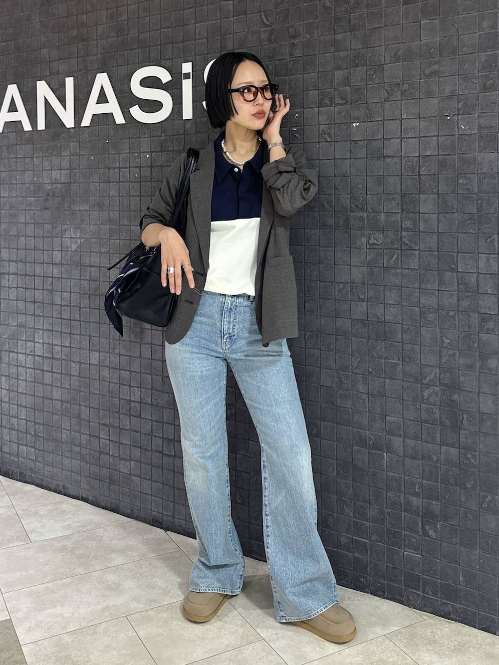 ブルー系のデニムパンツ、ベージュ系のローファー、ブラック系のトートバッグを着用したレディースの春コーディネートの7枚目の写真