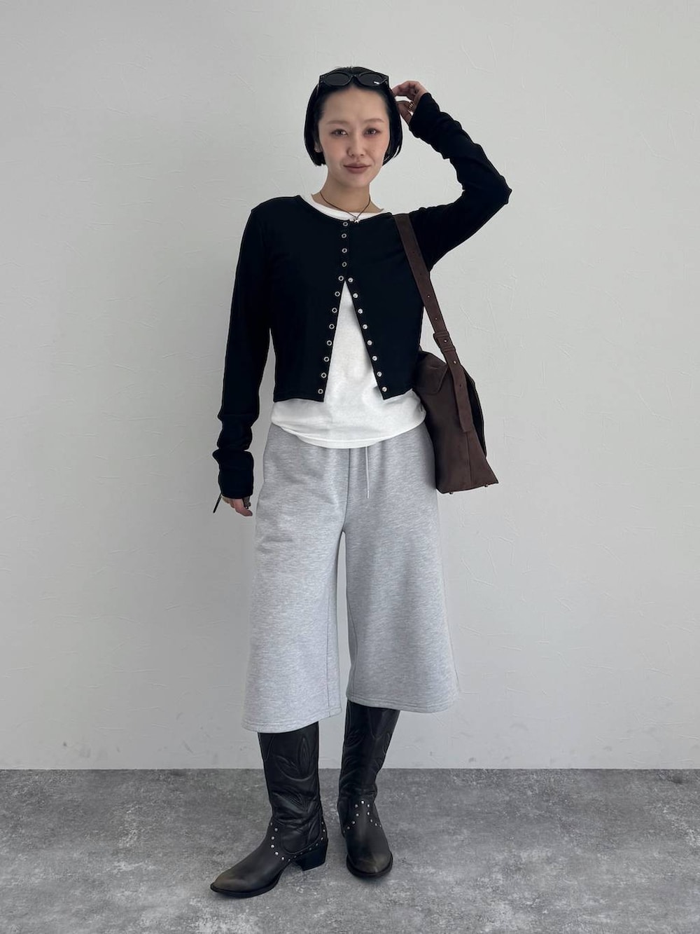 ブラック系のブーツ、ブラウン系のショルダーバッグを着用したレディースの冬コーディネートの6枚目の写真