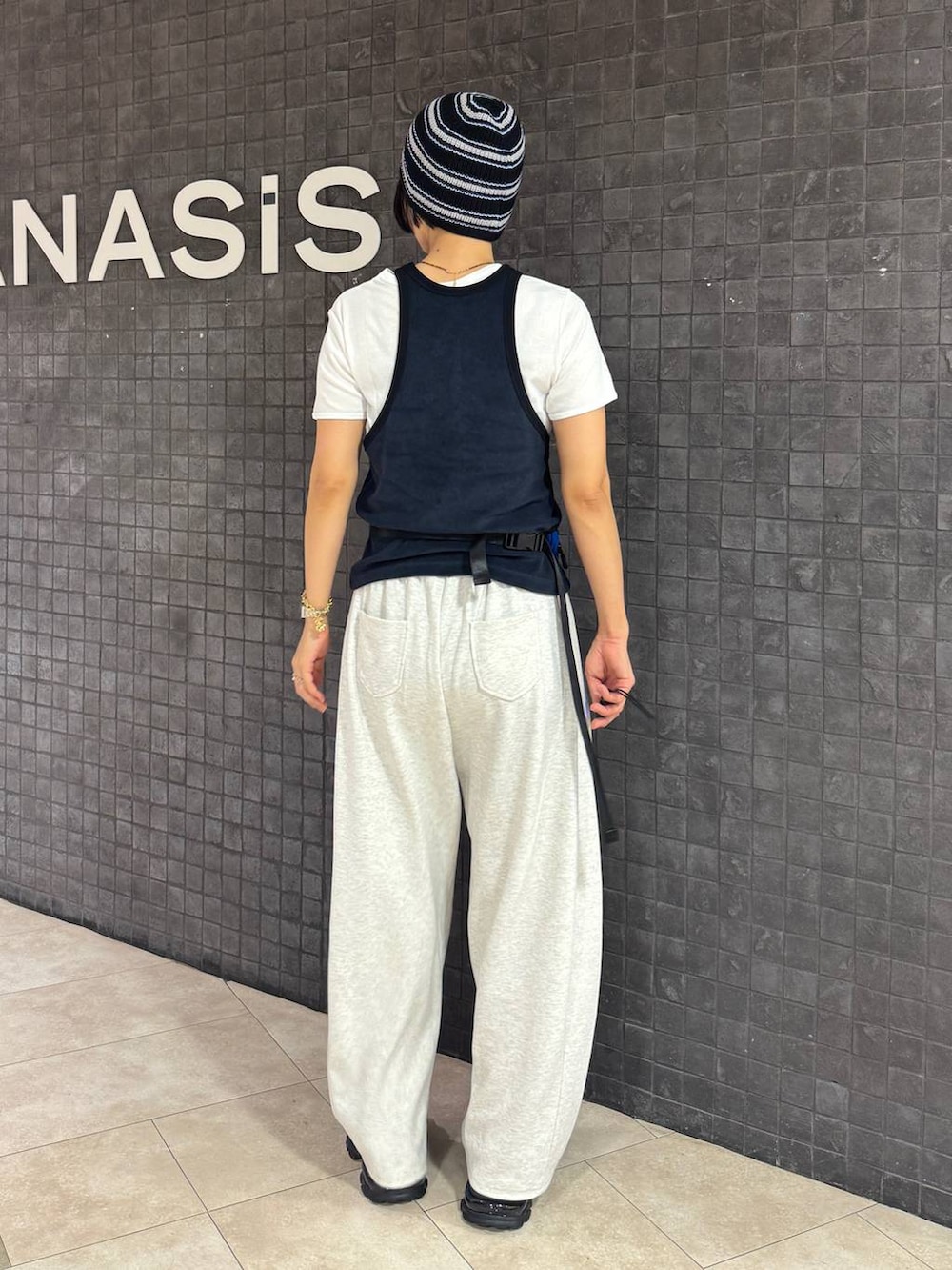 ブラック系のサンダル、ホワイト系のTシャツ/カットソー、ベージュ系のスウェットパンツを着用したレディースの夏コーディネートの4枚目の写真