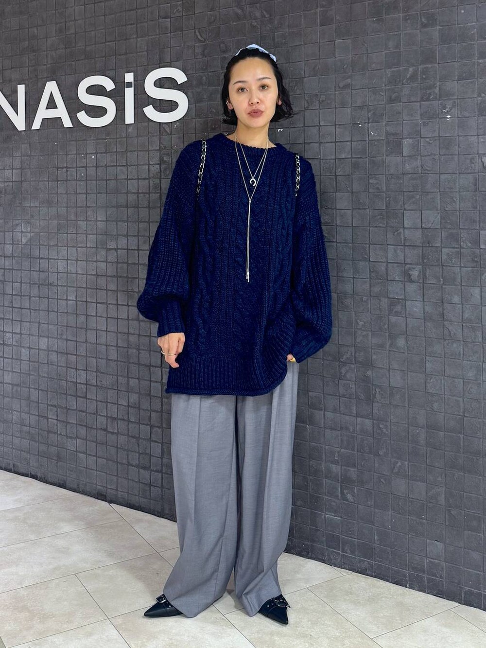 ブラック系のパンプス、グレー系のスラックスを着用したレディースの秋コーディネートの4枚目の写真