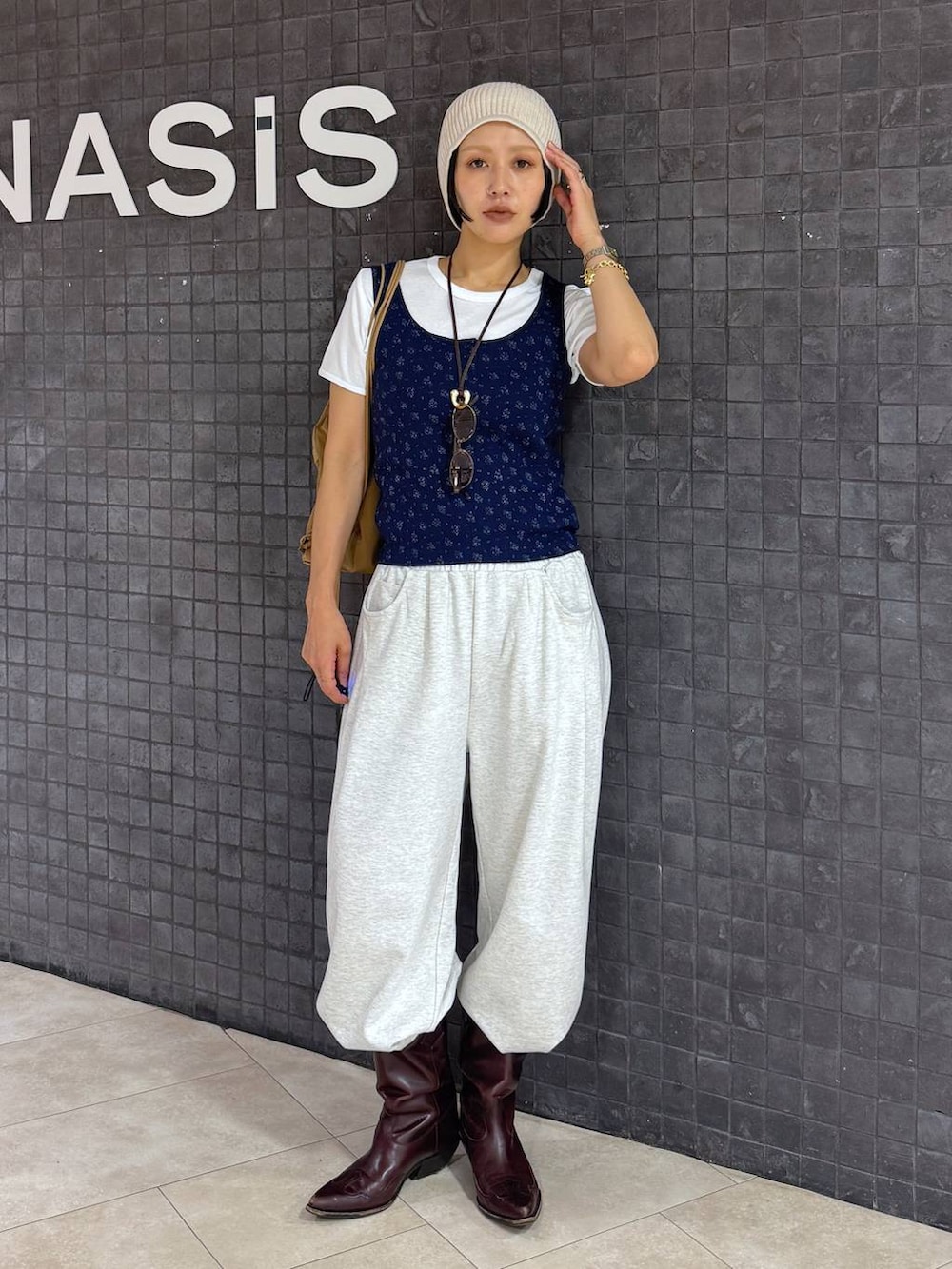 ブルー系のタンクトップ、ホワイト系のTシャツ/カットソー、ベージュ系のスウェットパンツを着用したレディースの夏コーディネートの4枚目の写真