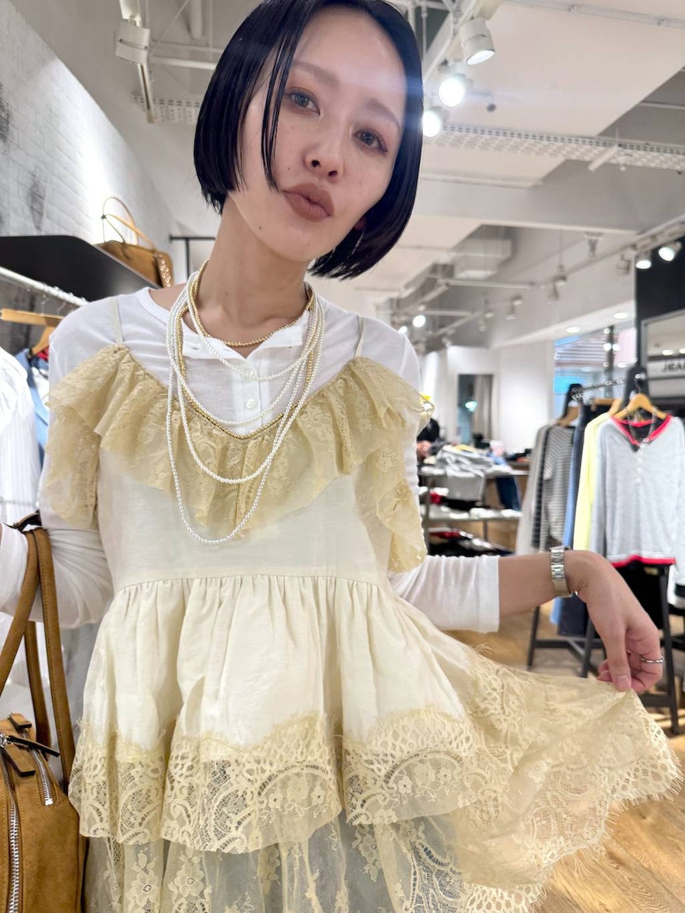 ホワイト系のTシャツ/カットソー、ブラウン系のボストンバッグ、ベージュ系のモカシン/デッキシューズを着用したレディースの春コーディネートの8枚目の写真