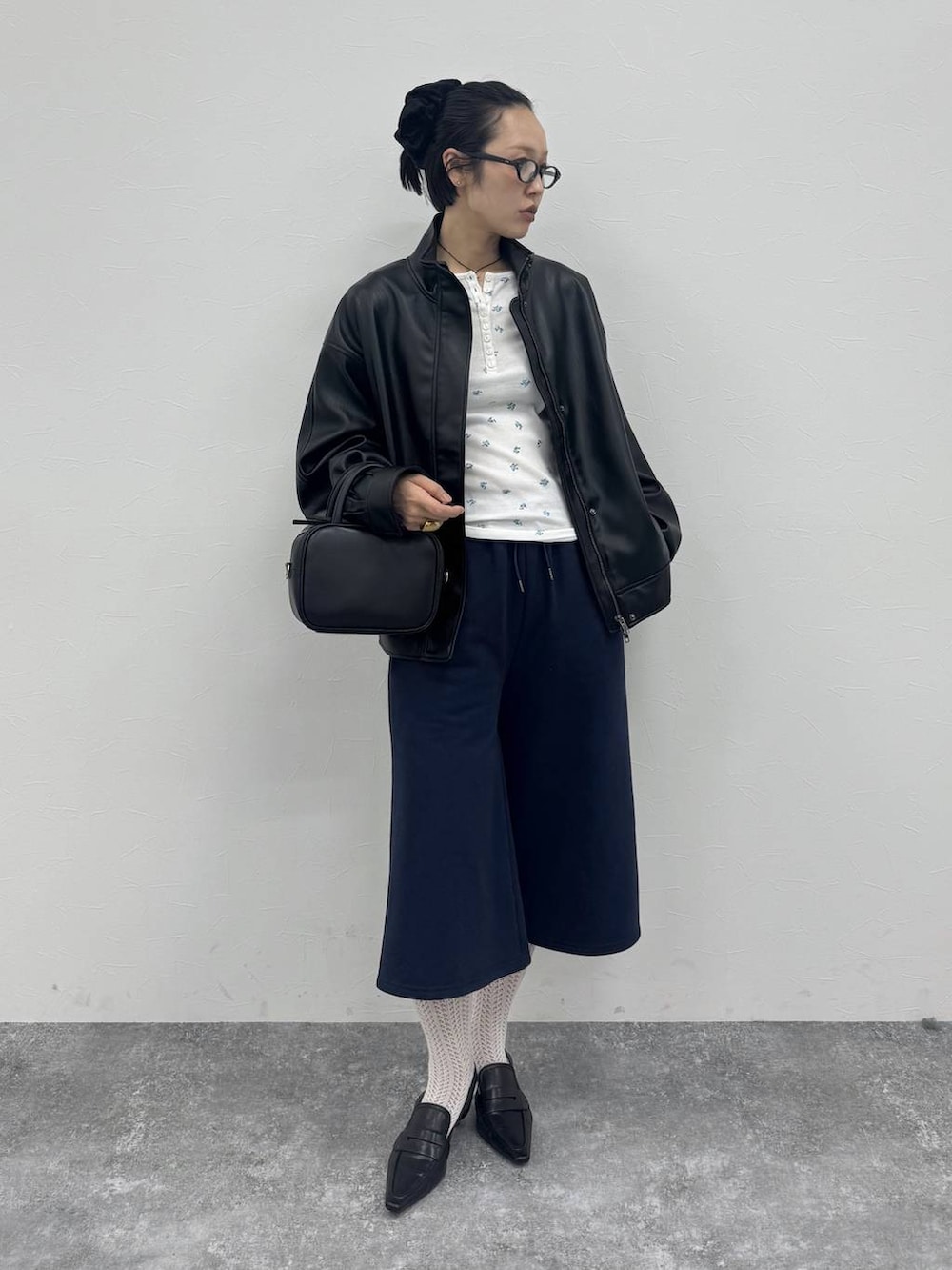 ブラック系のローファー、ブラック系のショルダーバッグ、ブラック系のブルゾンを着用したレディースの冬コーディネートの6枚目の写真