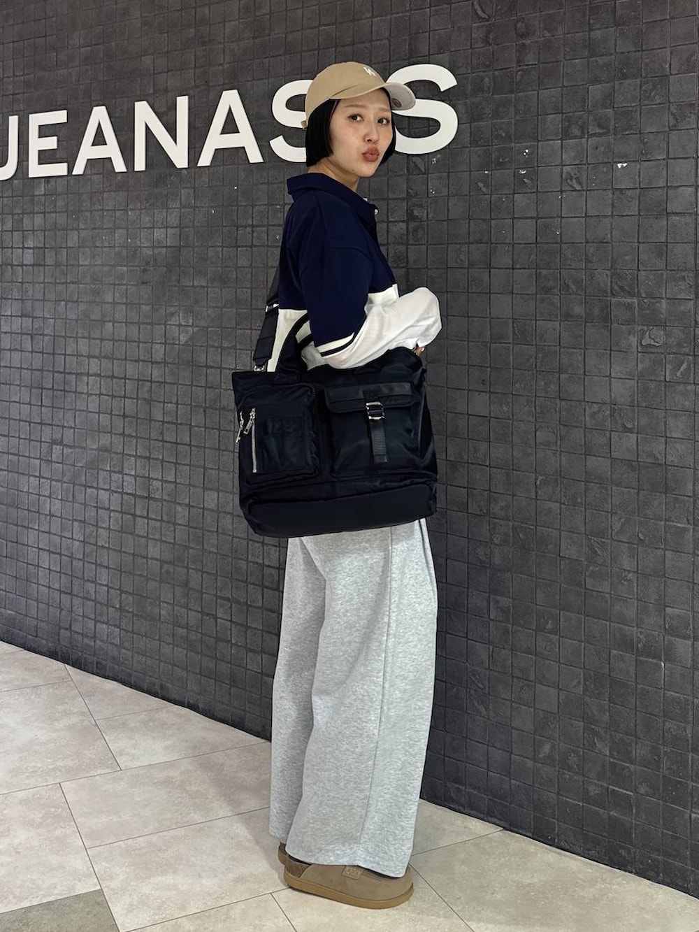 ブラック系のトートバッグ、ベージュ系のローファー、ホワイト系のシャツ/ブラウスを着用したレディースの春コーディネートの5枚目の写真