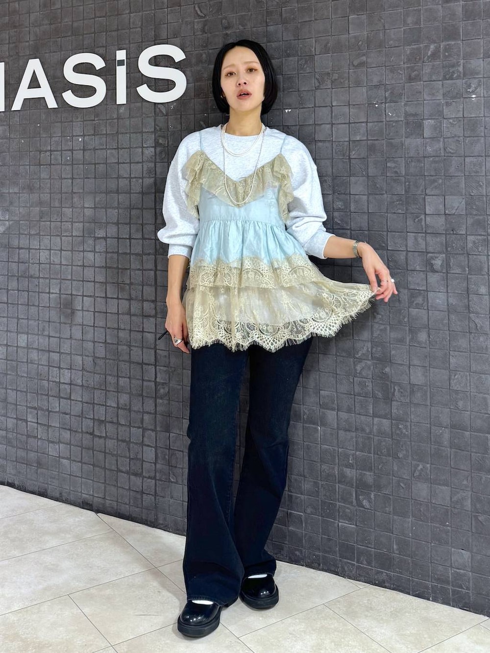 グレー系のスウェット、ブルー系のデニムパンツを着用したレディースの春コーディネートの3枚目の写真