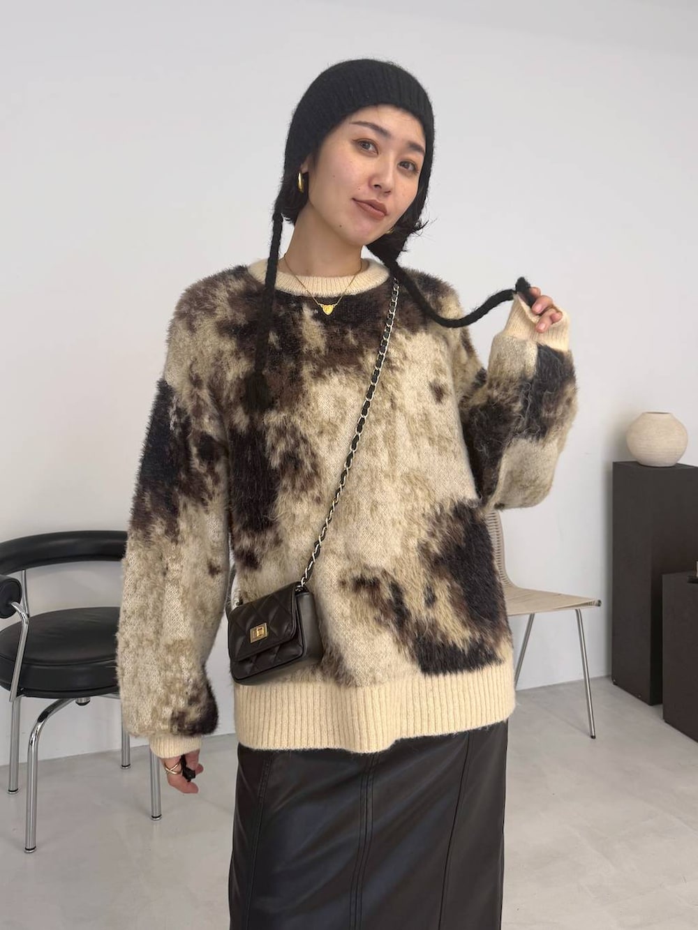 ブラウン系のニット/セーター、ブラック系のブーツ、ブラック系のスカートを着用したレディースの秋コーディネートの3枚目の写真