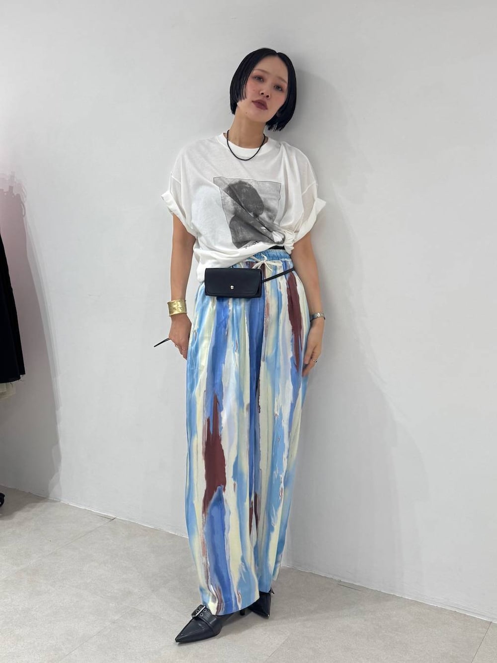 ブラック系のパンプス、ブルー系のその他パンツ、ホワイト系のTシャツ/カットソーを着用したレディースの春コーディネートの3枚目の写真