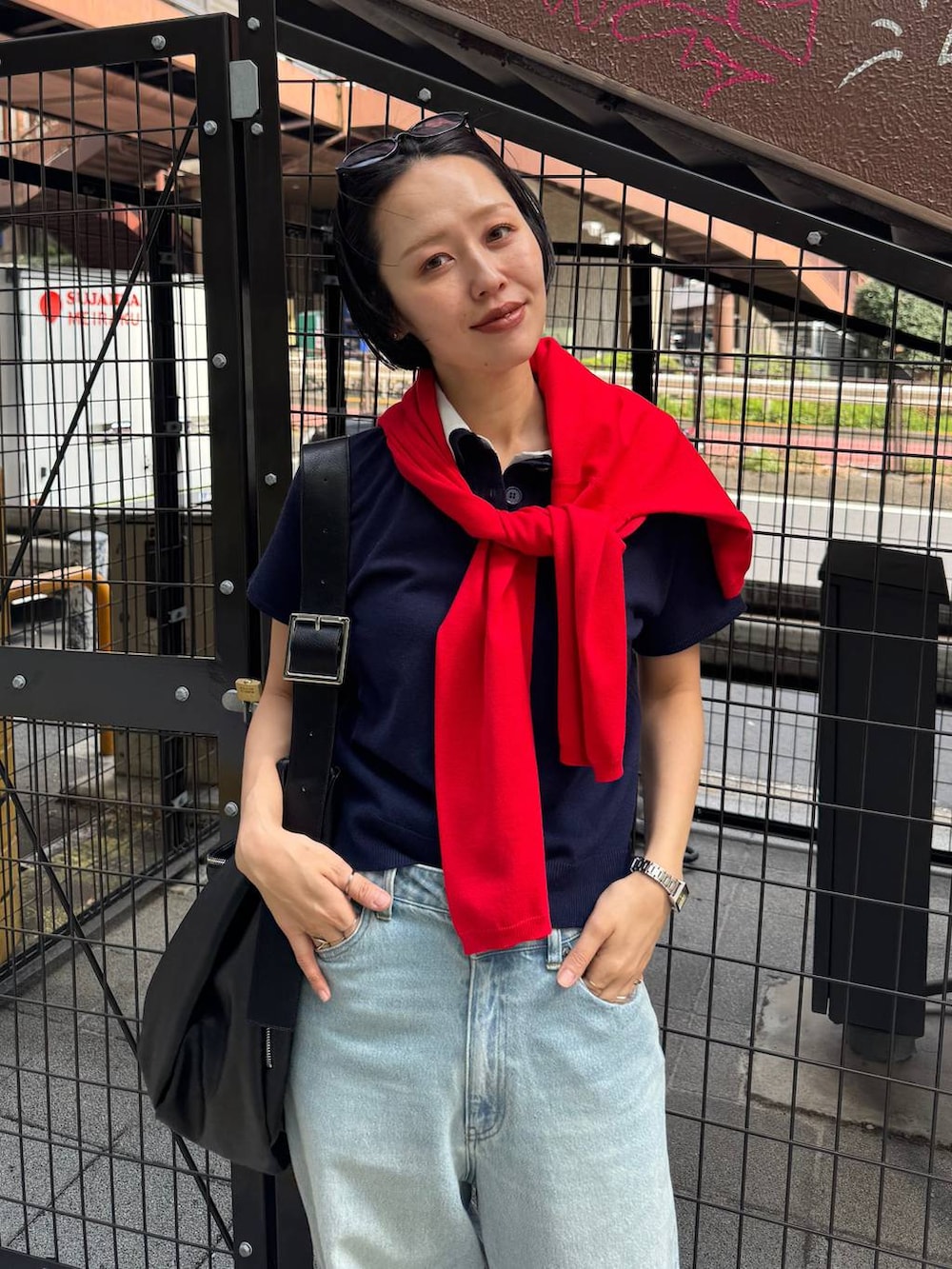 ブラック系のパンプス、ブルー系のデニムパンツを着用したレディースの春コーディネートの7枚目の写真