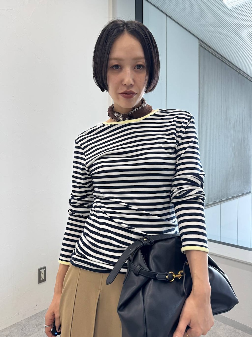 ブルー系のデニムパンツ、ブラック系のショルダーバッグ、ブラック系のサンダルを着用したレディースの夏コーディネートの4枚目の写真