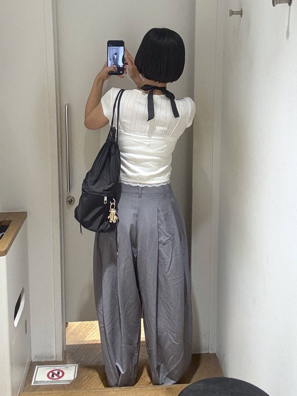 ブラック系のパンプス、グレー系のスラックス、ホワイト系のカーディガン/ボレロを着用したレディースの春コーディネートの5枚目の写真