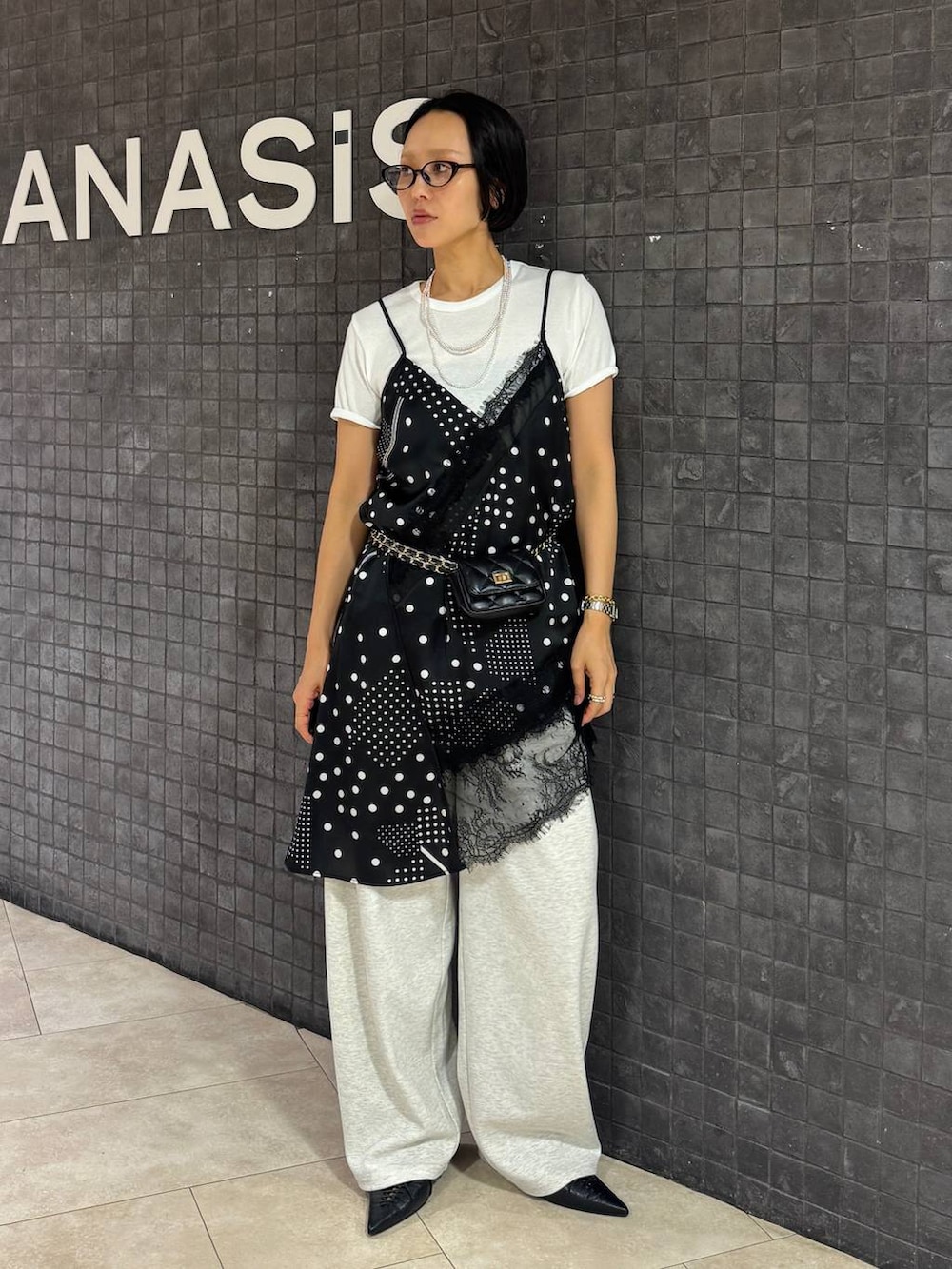 ブラック系のチュニック、ホワイト系のTシャツ/カットソー、ブラック系のパンプスを着用したレディースの夏コーディネートの3枚目の写真