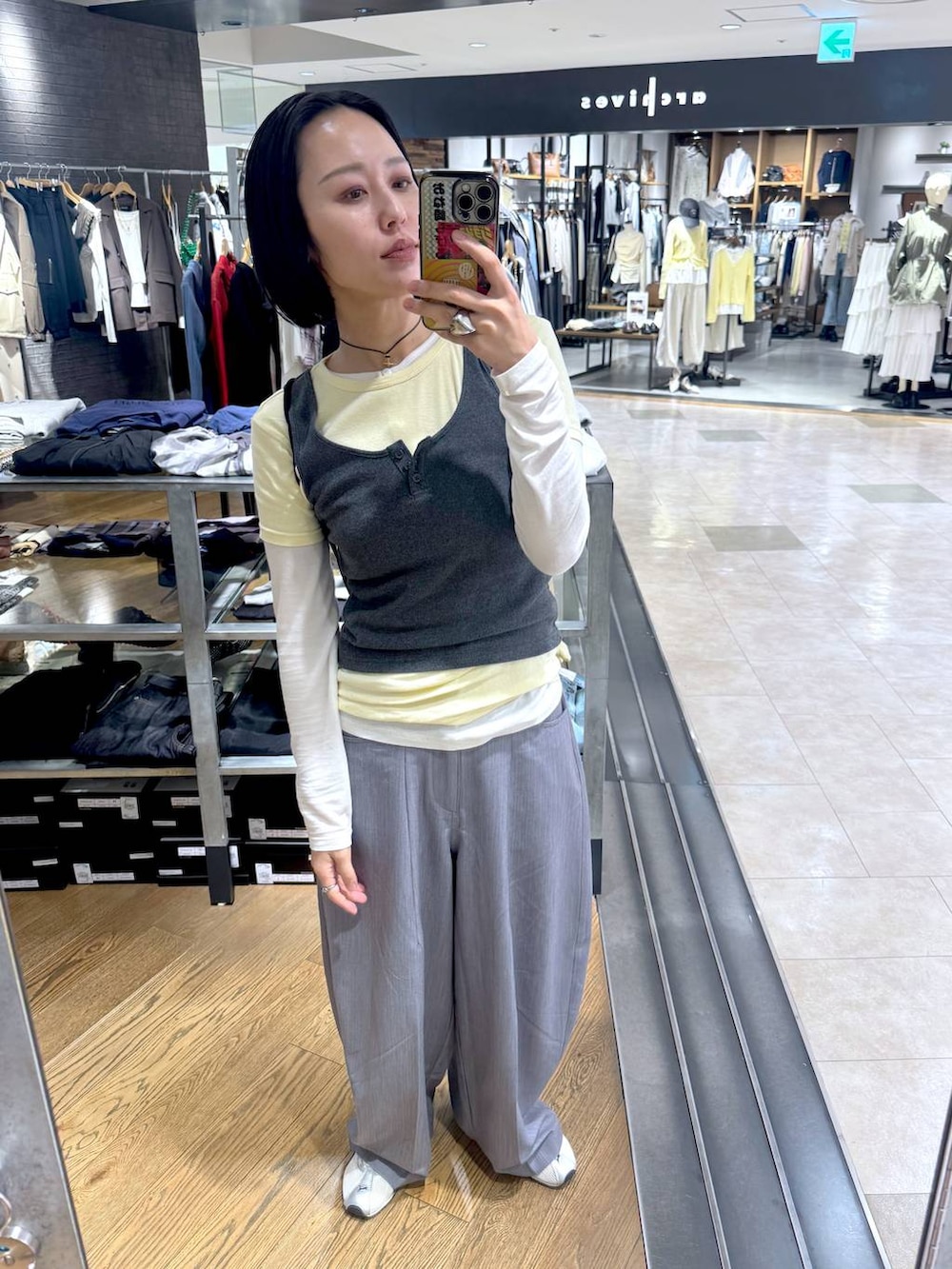 ホワイト系のTシャツ/カットソー、グレー系のタンクトップ、グレー系のスラックスを着用したレディースの春コーディネートの3枚目の写真