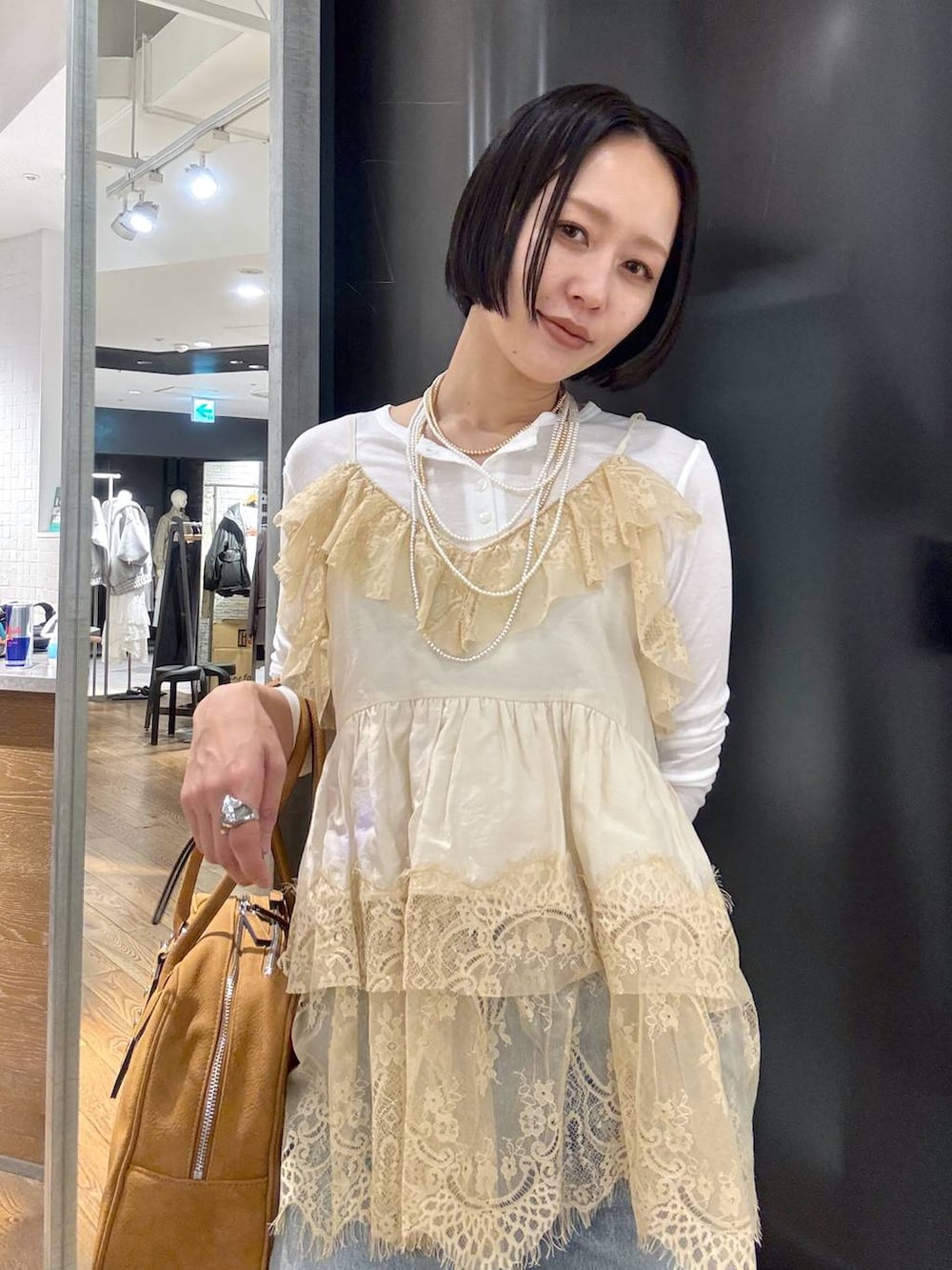 ホワイト系のTシャツ/カットソー、ブラウン系のボストンバッグ、ベージュ系のモカシン/デッキシューズを着用したレディースの春コーディネートの9枚目の写真