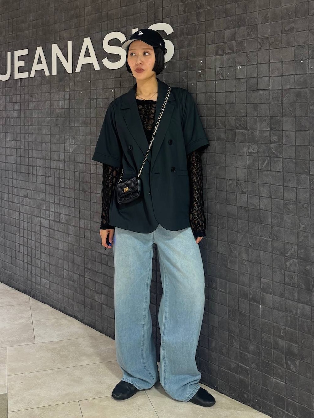ブラック系のTシャツ/カットソー、ブルー系のデニムパンツ、グレー系のテーラードジャケットを着用したレディースの春コーディネートの7枚目の写真