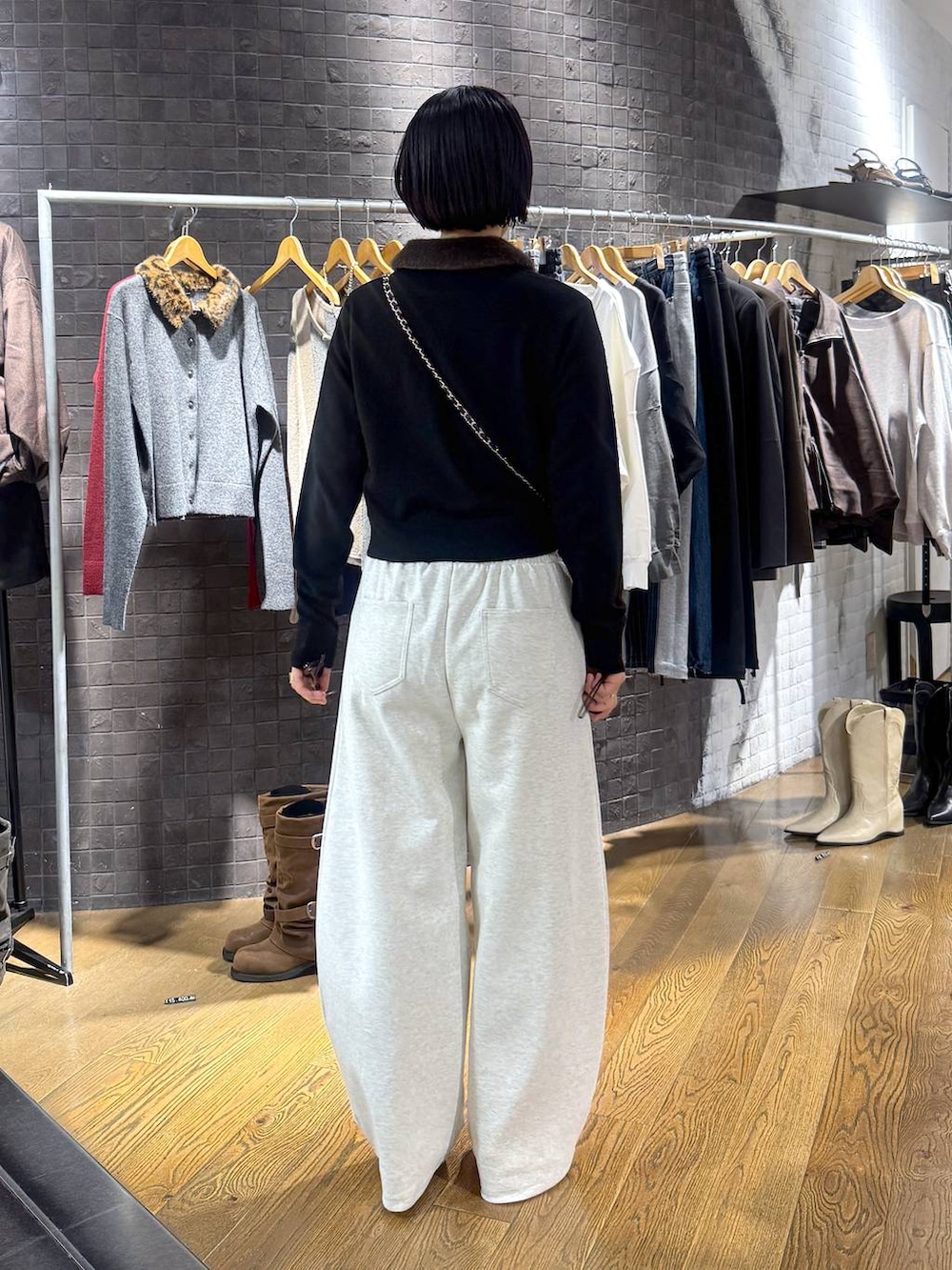 ブラック系のパンプス、ブラック系のカーディガン/ボレロ、ベージュ系のスウェットパンツを着用したレディースの秋コーディネートの3枚目の写真