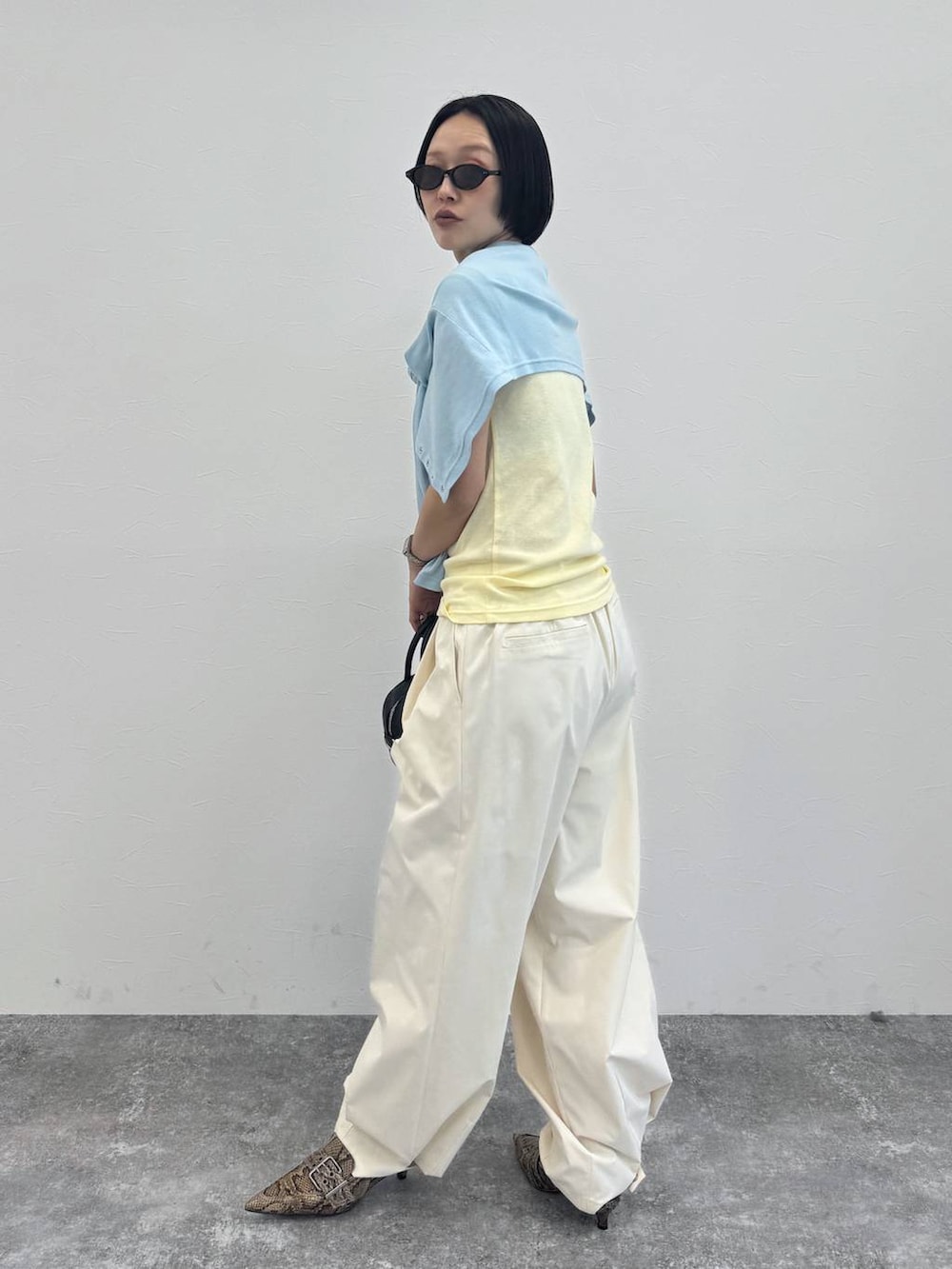 ブラック系のショルダーバッグ、ベージュ系のパンプス、ホワイト系のその他パンツを着用したレディースの冬コーディネートの2枚目の写真