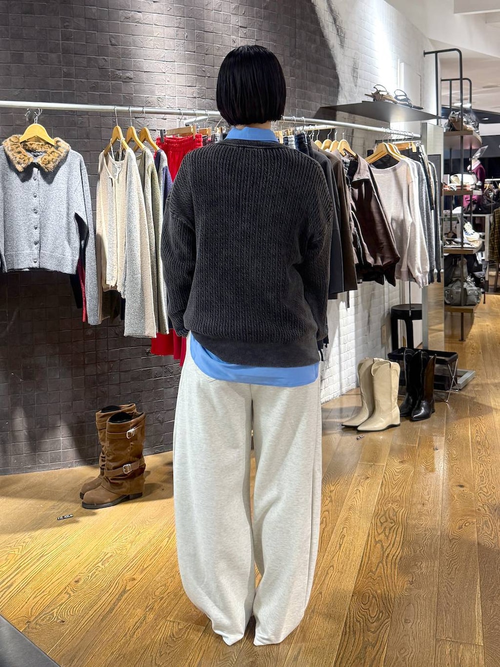 ブルー系のシャツ/ブラウス、ブラック系のニット/セーター、ベージュ系のスウェットパンツを着用したレディースの秋コーディネートの3枚目の写真