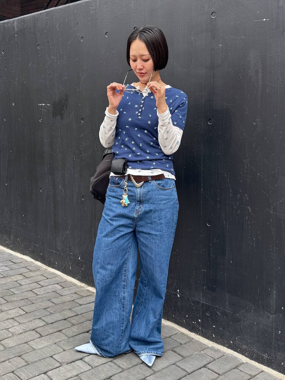 ブラック系のバックパック/リュック、ブルー系のTシャツ/カットソー、ブラウン系のベルトを着用したレディースの春コーディネートの7枚目の写真