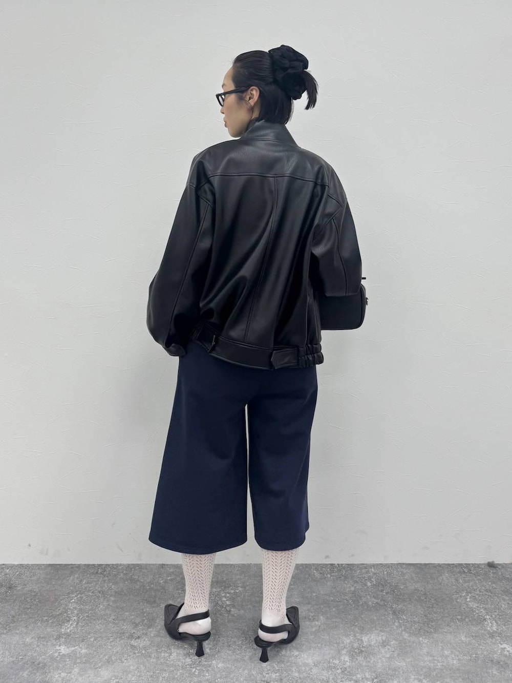 ブラック系のローファー、ブラック系のショルダーバッグ、ブラック系のブルゾンを着用したレディースの冬コーディネートの4枚目の写真