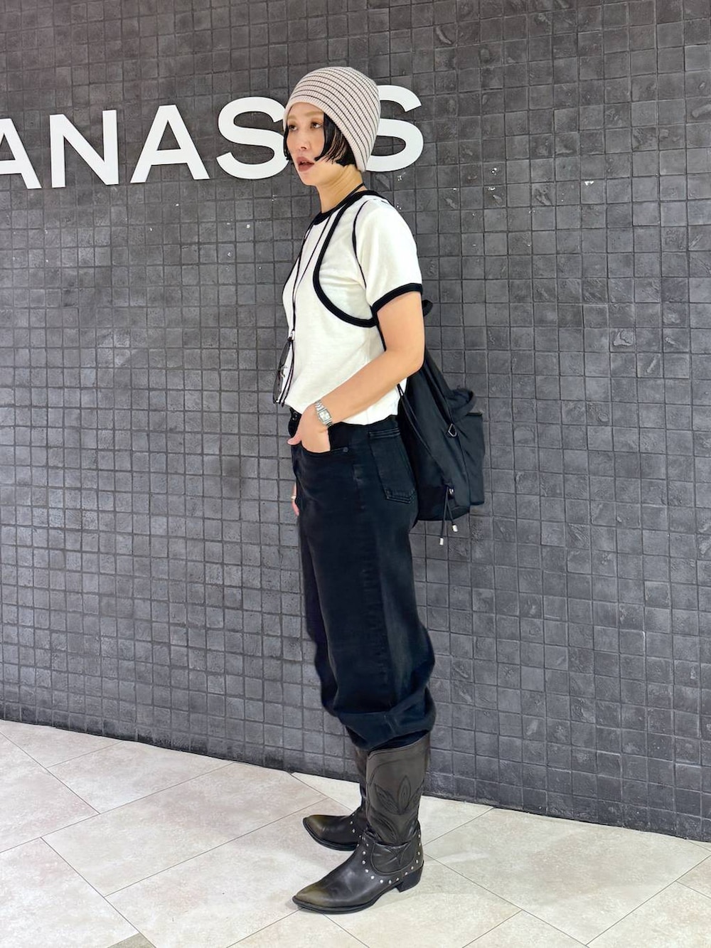 ブラック系のブーツ、ブラック系のデニムパンツ、ホワイト系のニットキャップ/ビーニーを着用したレディースの夏コーディネートの2枚目の写真