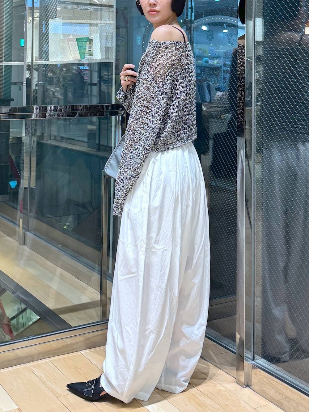 ブラック系のパンプス、ブルー系のボストンバッグ、ブラック系のニット/セーターを着用したレディースの春コーディネートの3枚目の写真