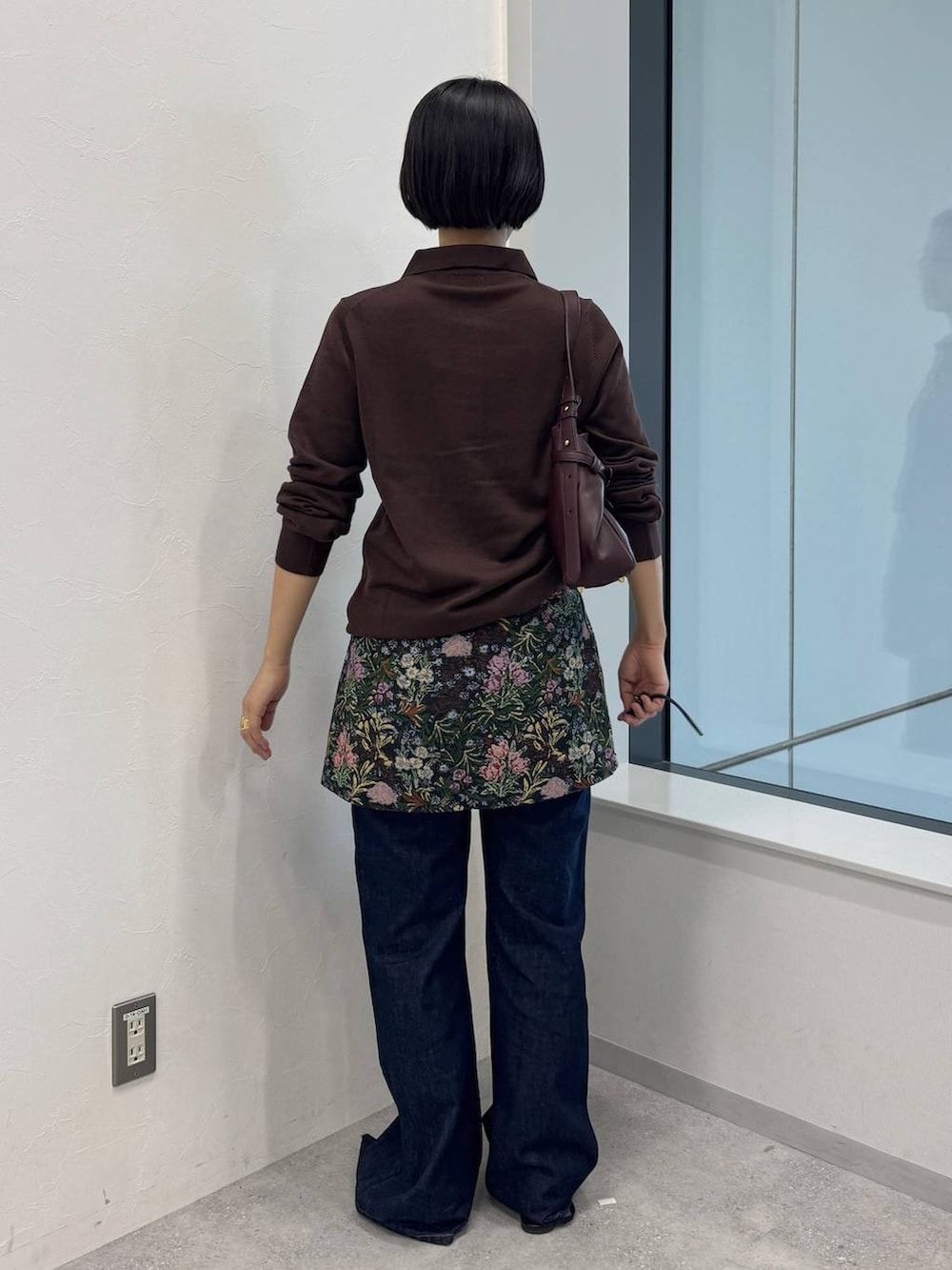 レッド系のショルダーバッグ、ブルー系のデニムパンツ、ブラック系のスカートを着用したレディースの夏コーディネートの3枚目の写真
